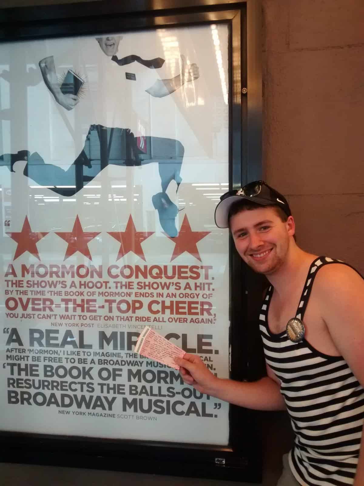 New York City: Must Sees & Maybe Passes 13 Colin in front of the Book of Mormon poster with tickets