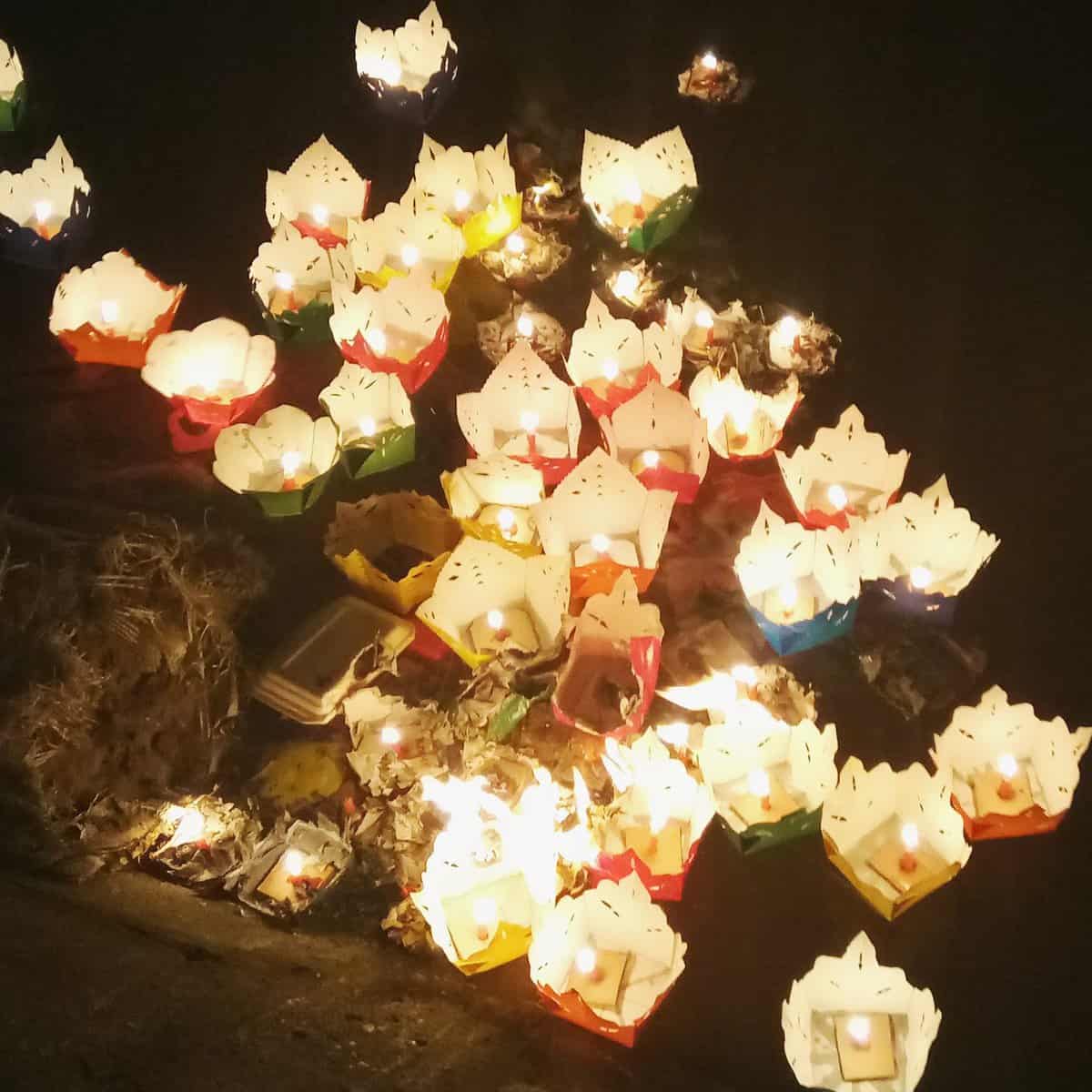 The Disneyland of Vietnam: Hoi An 5 Lanterns with candles in them floating on the river in Hoi An, Vietnam