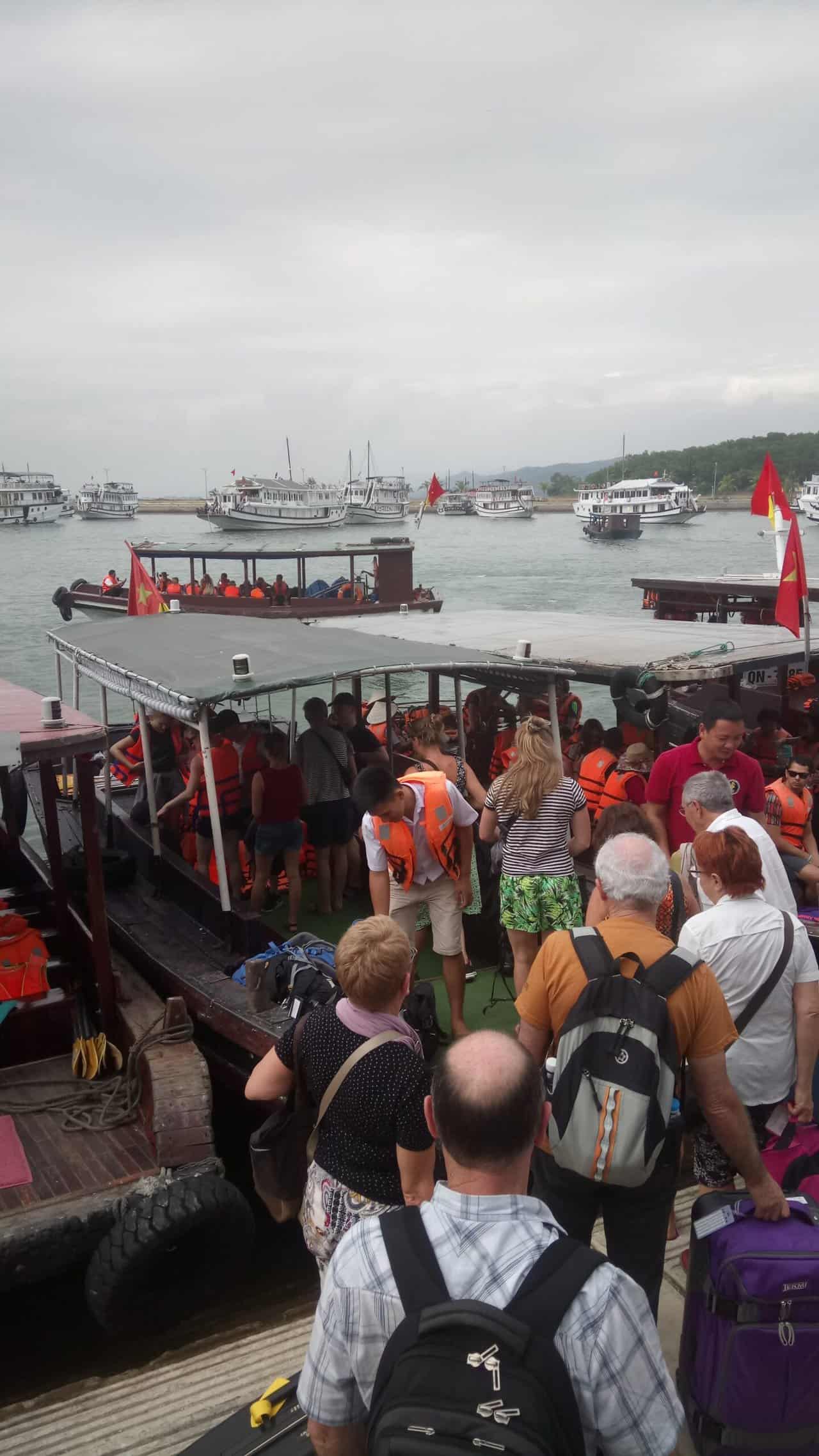 My Halong Bay Cruise Experience in Vietnam 5 Travellers getting on small boats at Halong Marina to take them out to their cruise boats