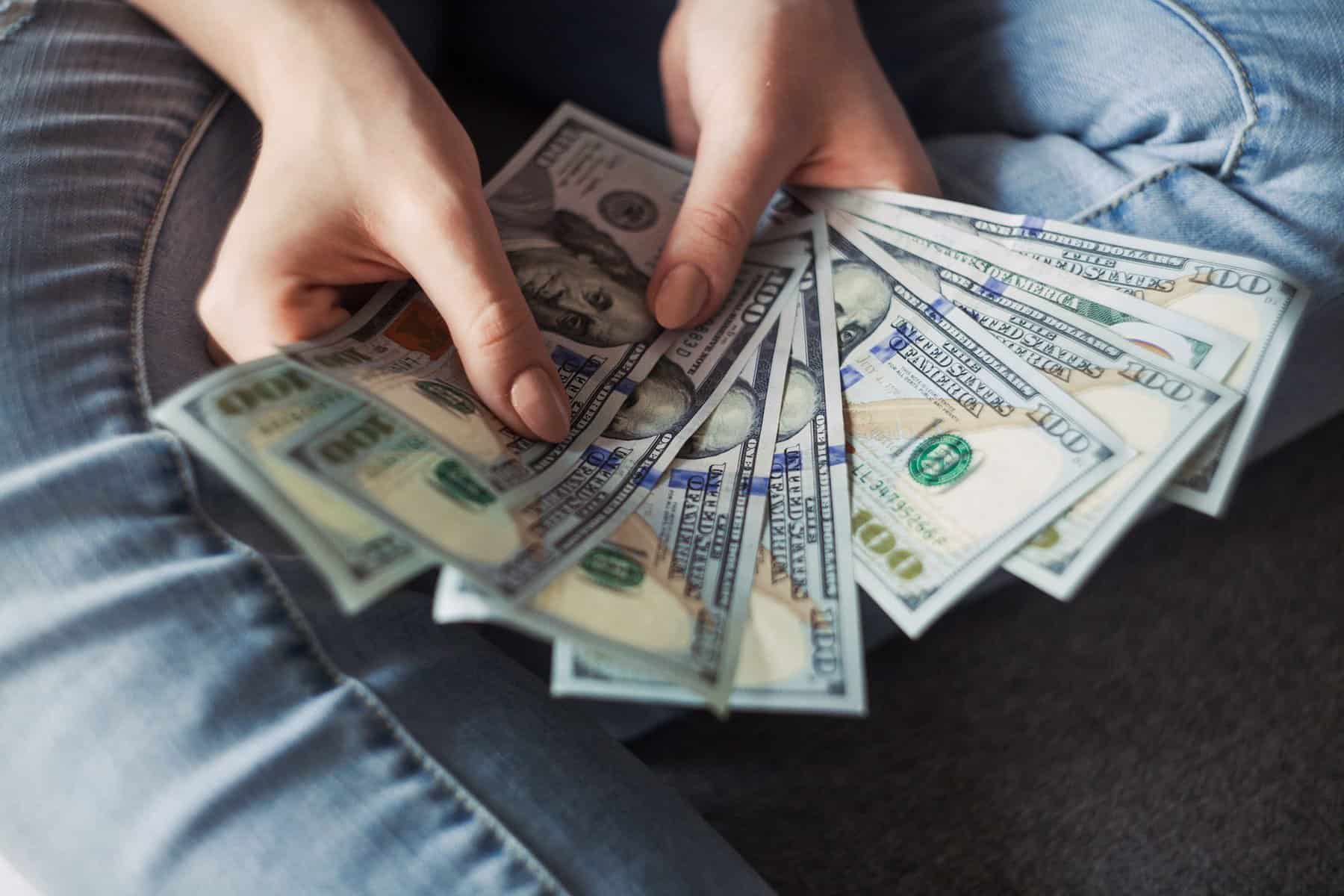 7 Tips for Managing Finances as a Couple 2 person's hands holding $100 bills