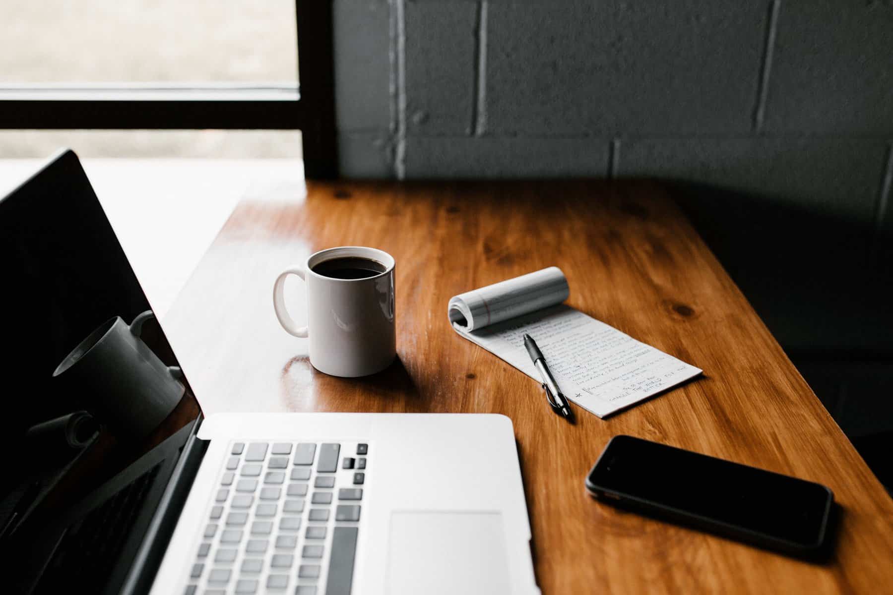 How to Quit a Freelance Job 3 laptop, coffee, notepad and phone on wooden desk; freelance work