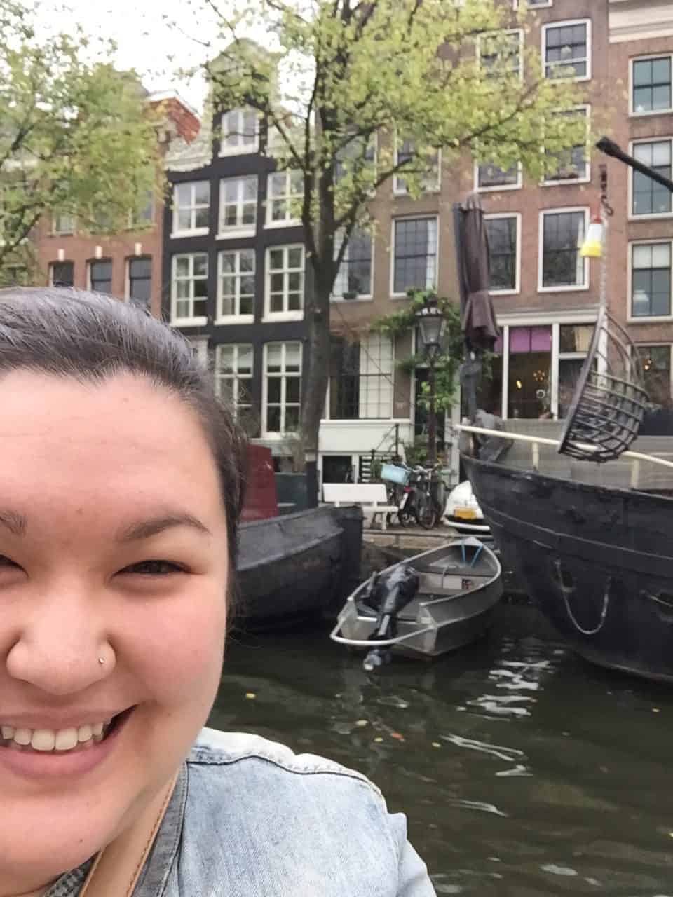 Falling Back in Love with Amsterdam 7 Selfie of Riana smiling on a boat going down the canals of Amsterdam