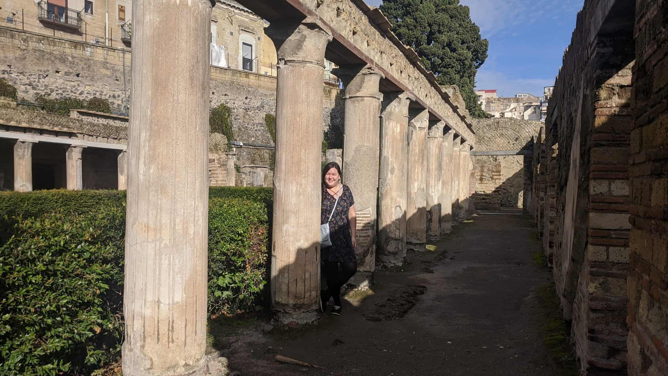 Riana standing next to columns in Herculaneum, Italy