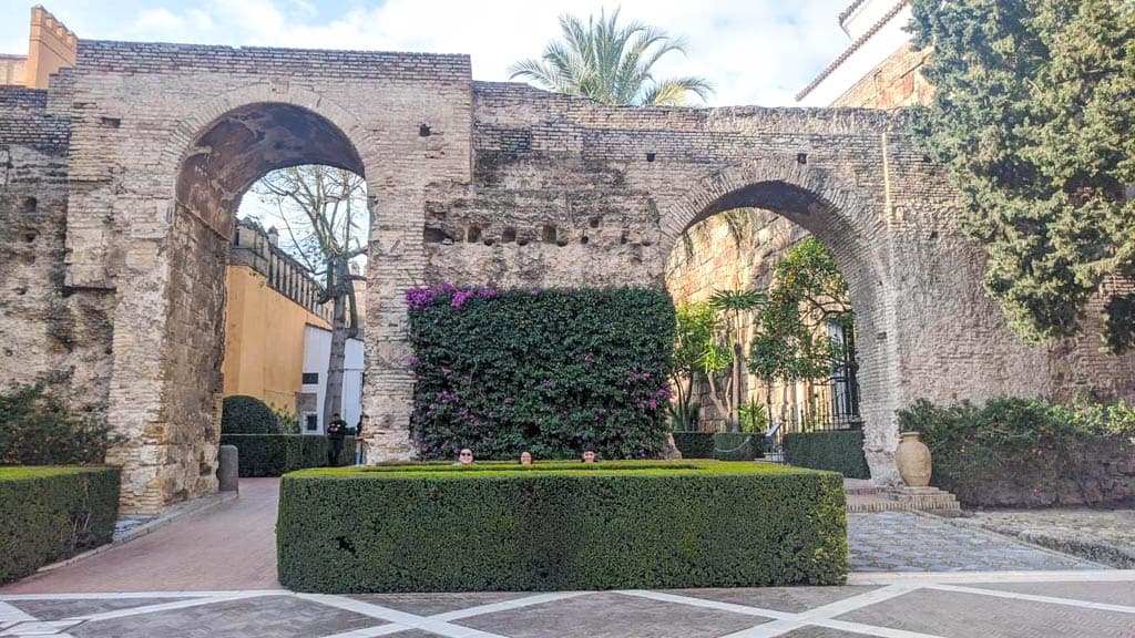 Falling in Love with Seville 24 Riana and her siblings hiding behind a hedge at the entrance to the Royal Alcazar of Seville
