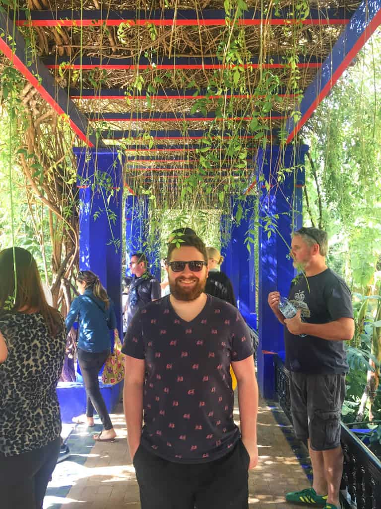 Colin smiling under a walkway at Jardin Majorelle in Marrakech Morocco 