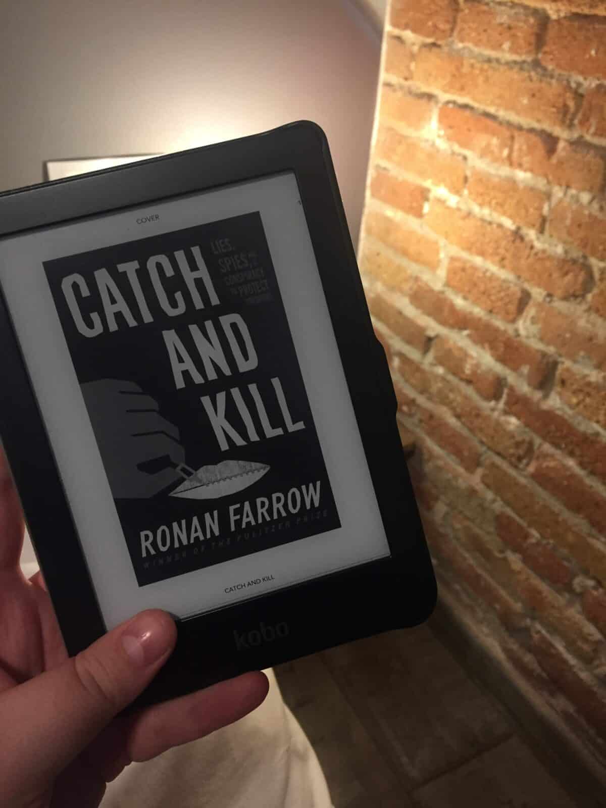 40+ Beach Reads for Every Reading Mood 26 Ebook of Catch and Kill by Ronan Farrow next to a brick wall
