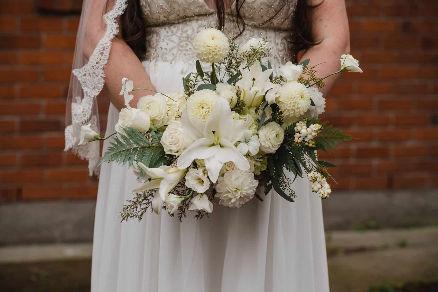 Which Wedding Traditions Did We Actually End Up Skipping? 16 Riana holding a bridal bouquet with white flowers and greenery