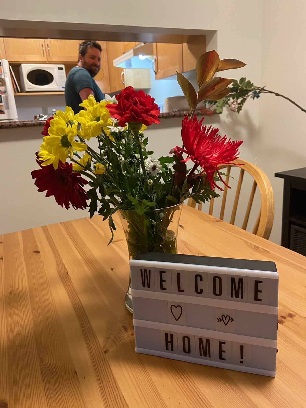 welcome home sign and flowers from Colin 