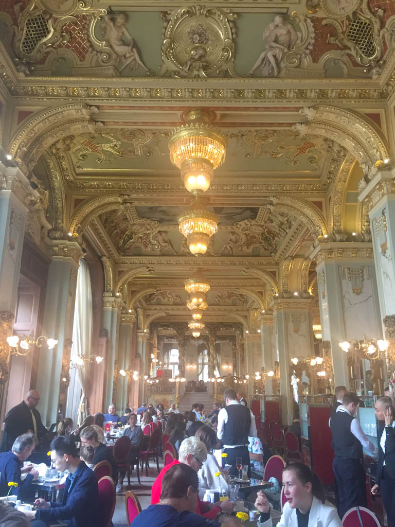 Is the New York Cafe Budapest Worth It? (Full Review) 2 New York Cafe in Budapest, Hungary, gilded ceiling and lights in the busy main dining room