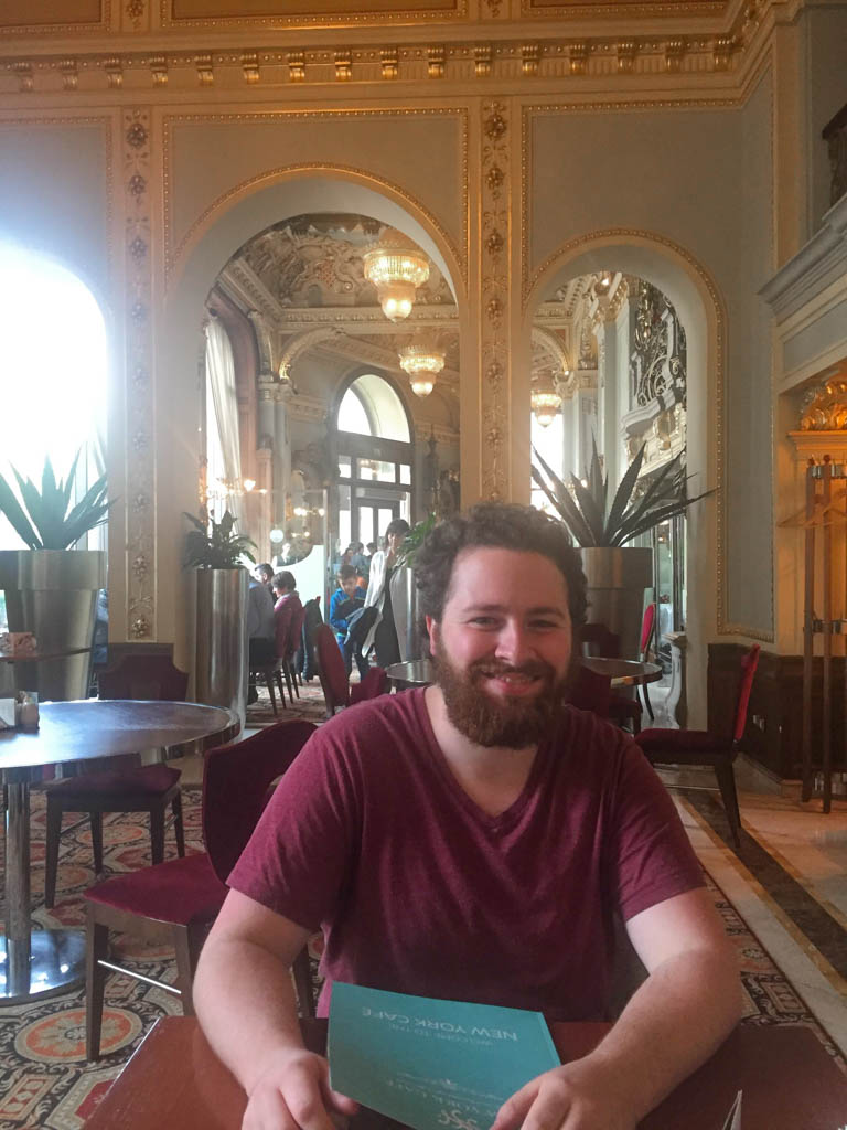 Is the New York Cafe Budapest Worth It? (Full Review) 6 Colin seated in the ugly room at the new york cafe, new york cafe photos, budapest hungary