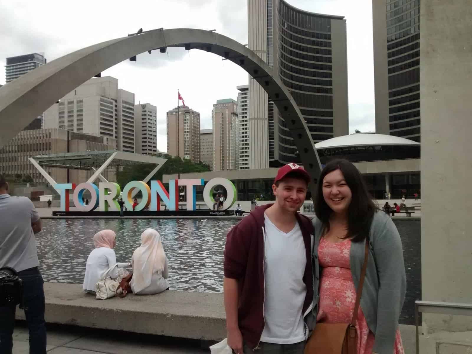 Riana and Colin in front of the Toronto sign at Nathan Phillip Square in 2015