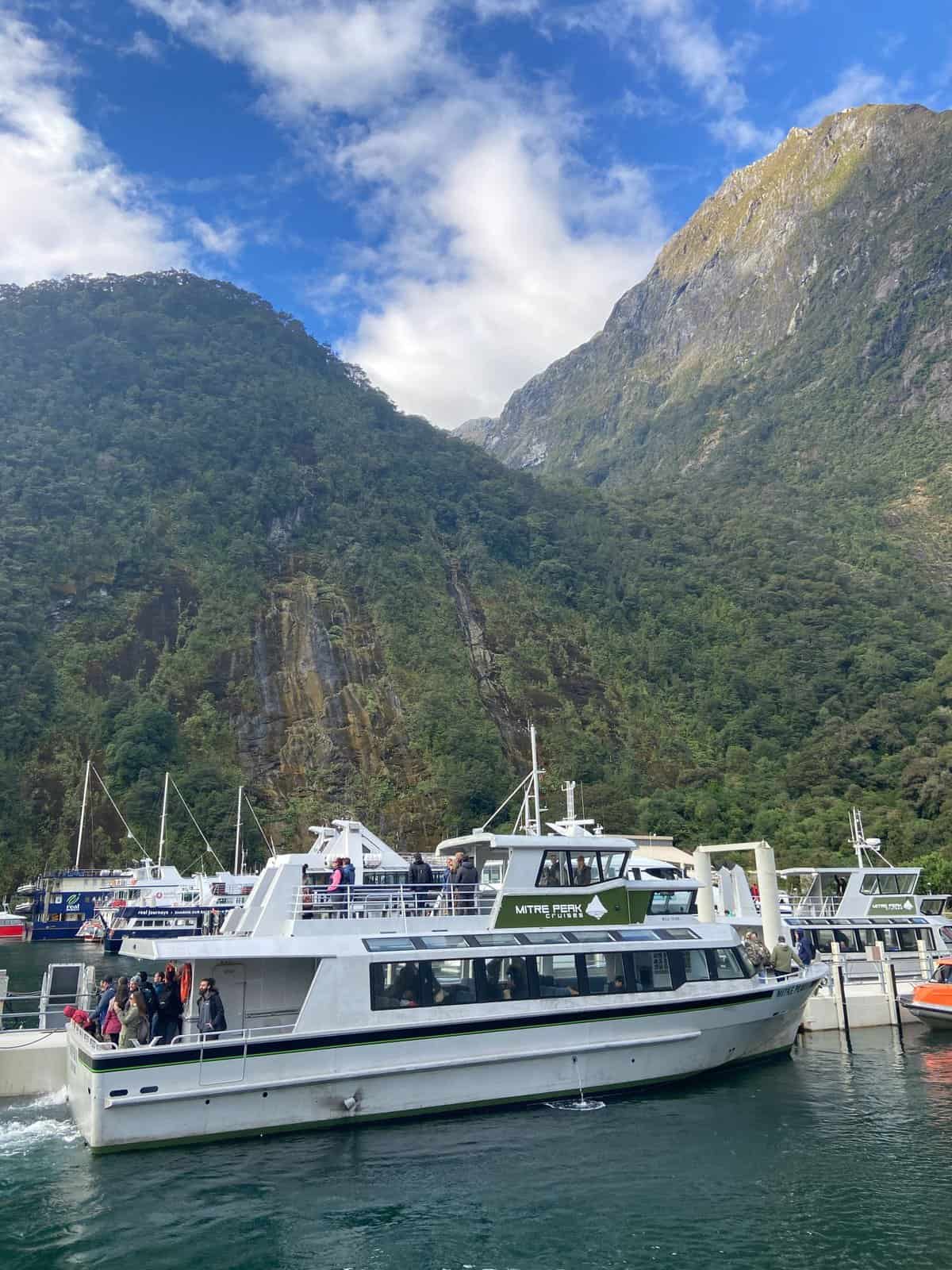 Mitre Peak Cruises boat pulling into the harbour at Milford Sound, New Zealand