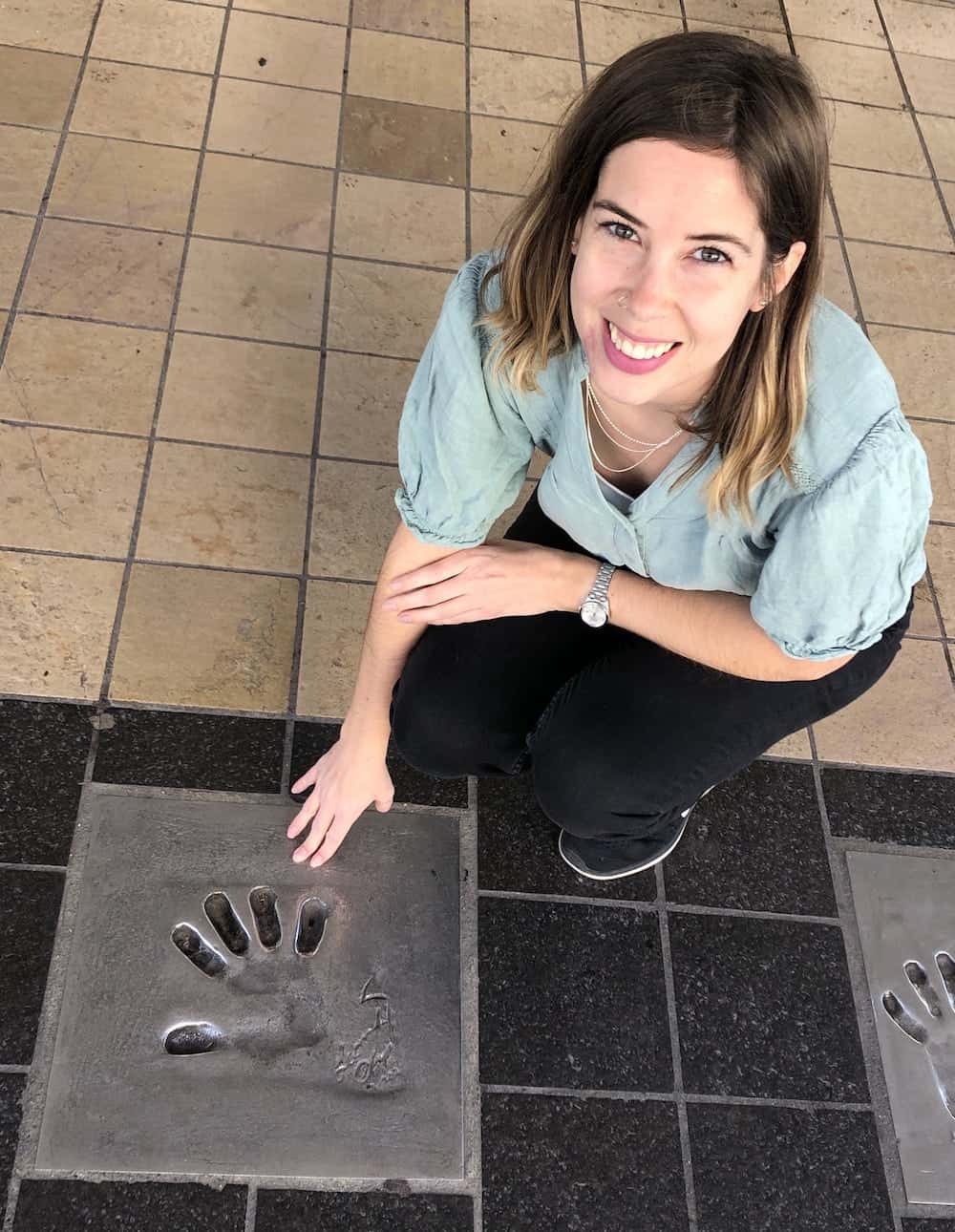 Melanie posing with Leonardo diCaprio's handprint in Cannes