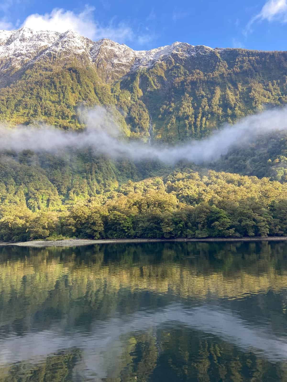 Clouds lifting off the water in Doubtful Sound