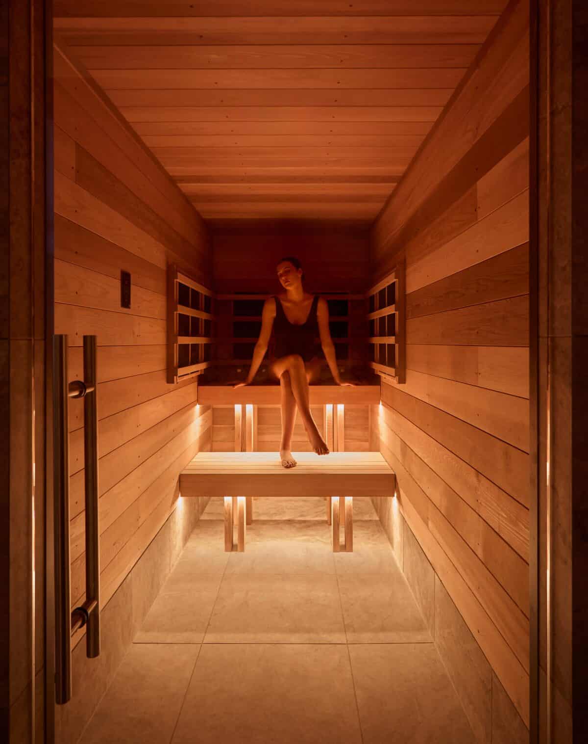What to Do in Queenstown (If You're Not an Adrenaline Junkie) 11 A woman sitting on a bench inside The Bathhouse Spa Queenstown Infrared Sauna