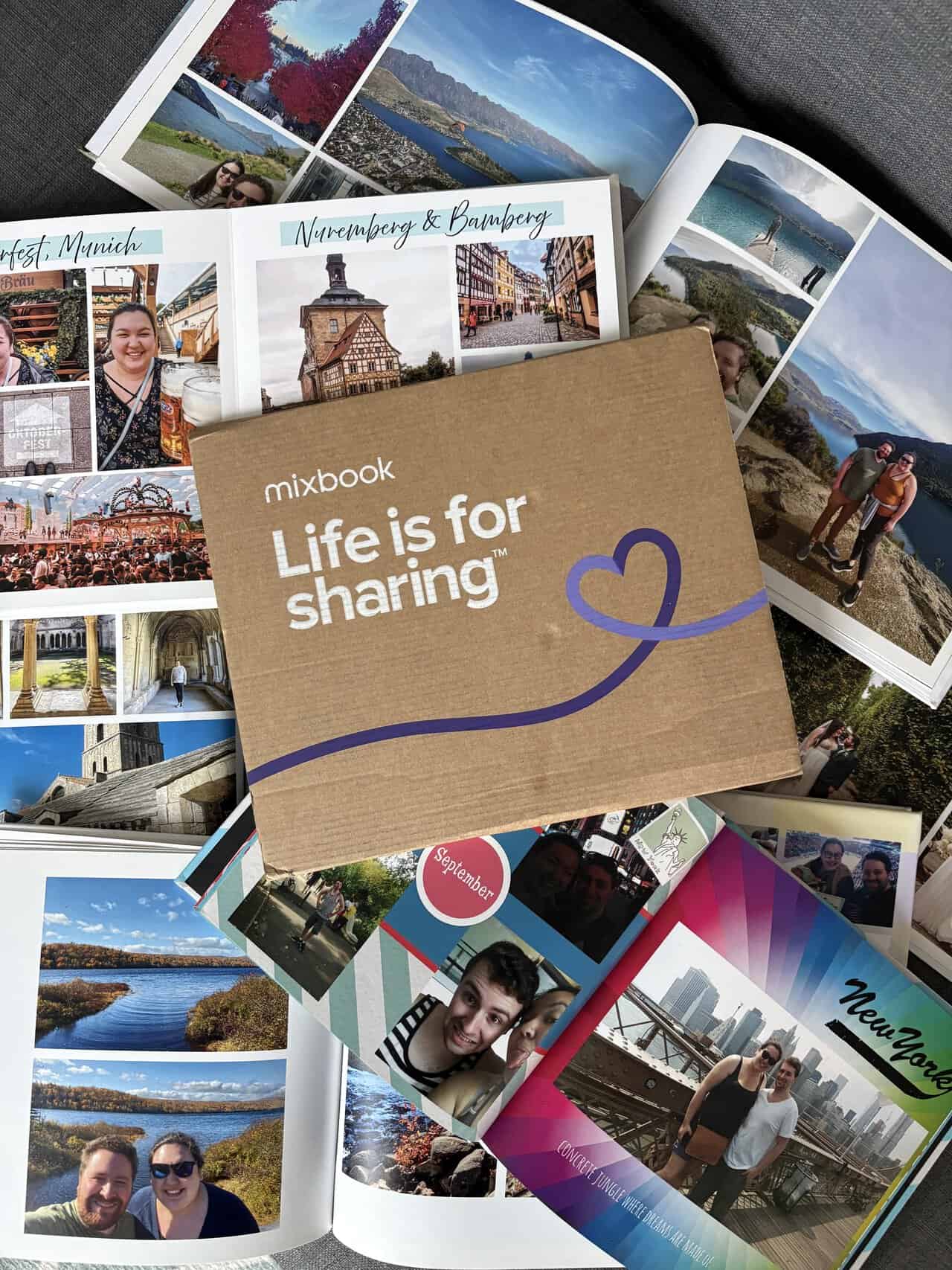 Mixbook cardboard package on top of pile of photo books opened to the photo pages