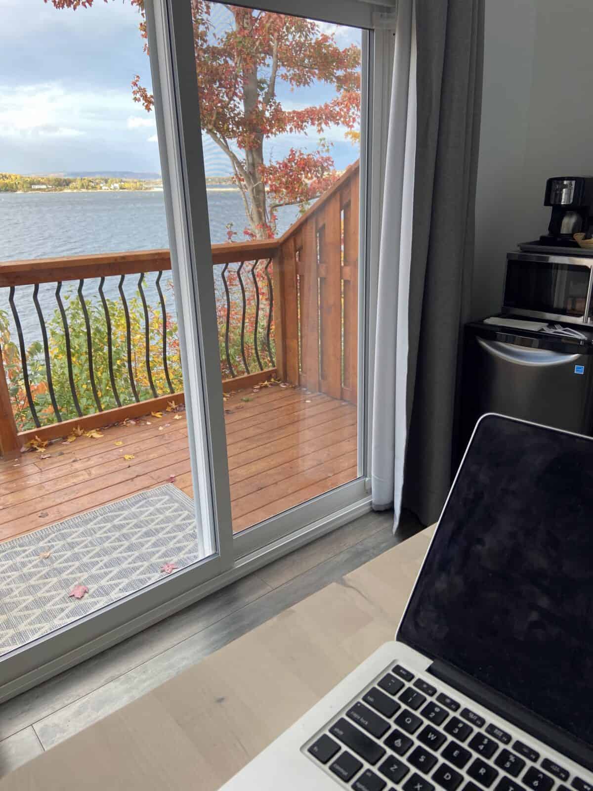 18 Freelancer Tips for Beginners (From an 8 Year Veteran!) 5 Laptop sitting on a desk with a view of fall foliage out the screen door behind it
