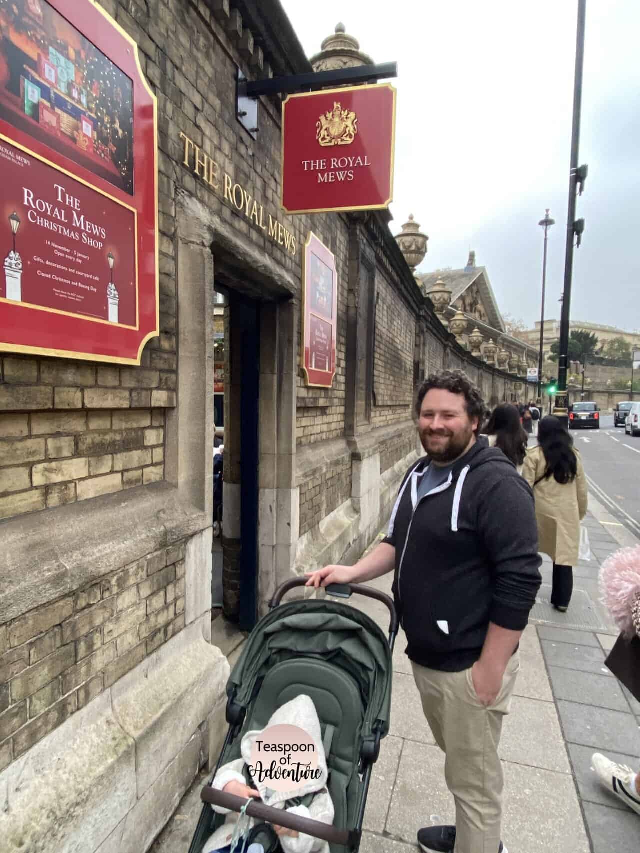 Colin and Baby C standing in front of The Royal Mews Christmas Shop at Buckingham Palace in London, England