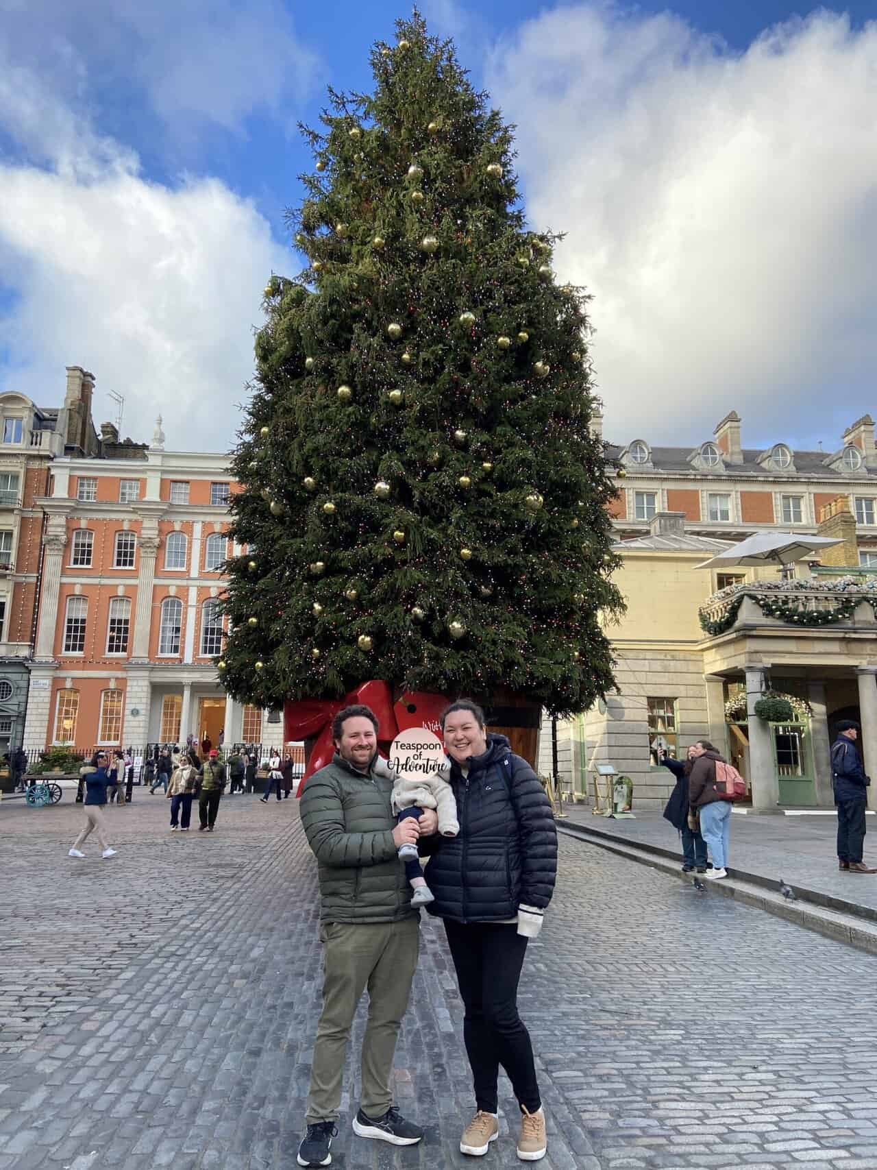 Riana, Colin and Baby C in front of the Christmas tree at Covent Garden in London
