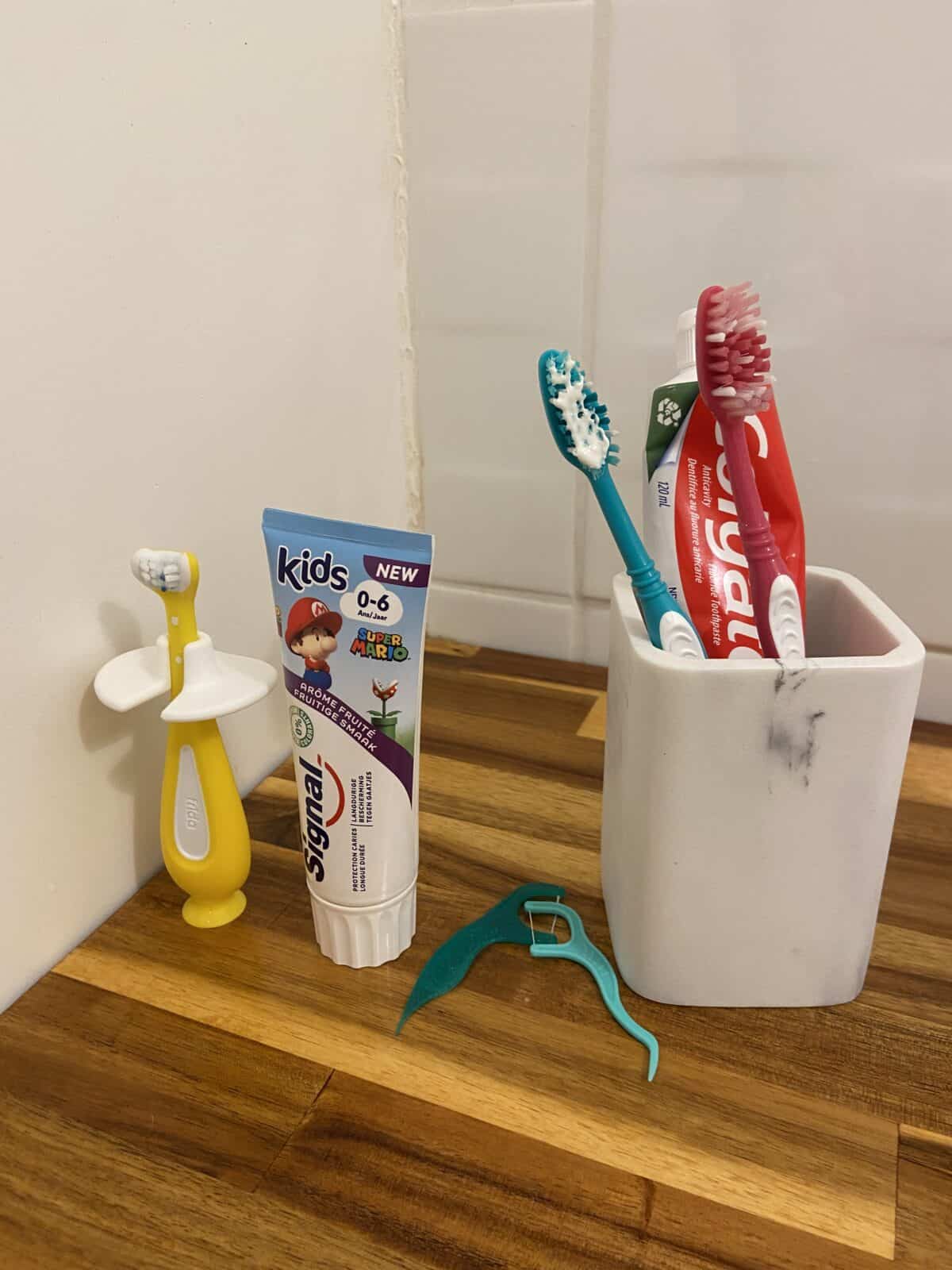 Our Essential Packing List for Travel with a Baby 37 Baby C's tiny toothbrush and toothpaste next to our adult toothbrushes and toothpaste