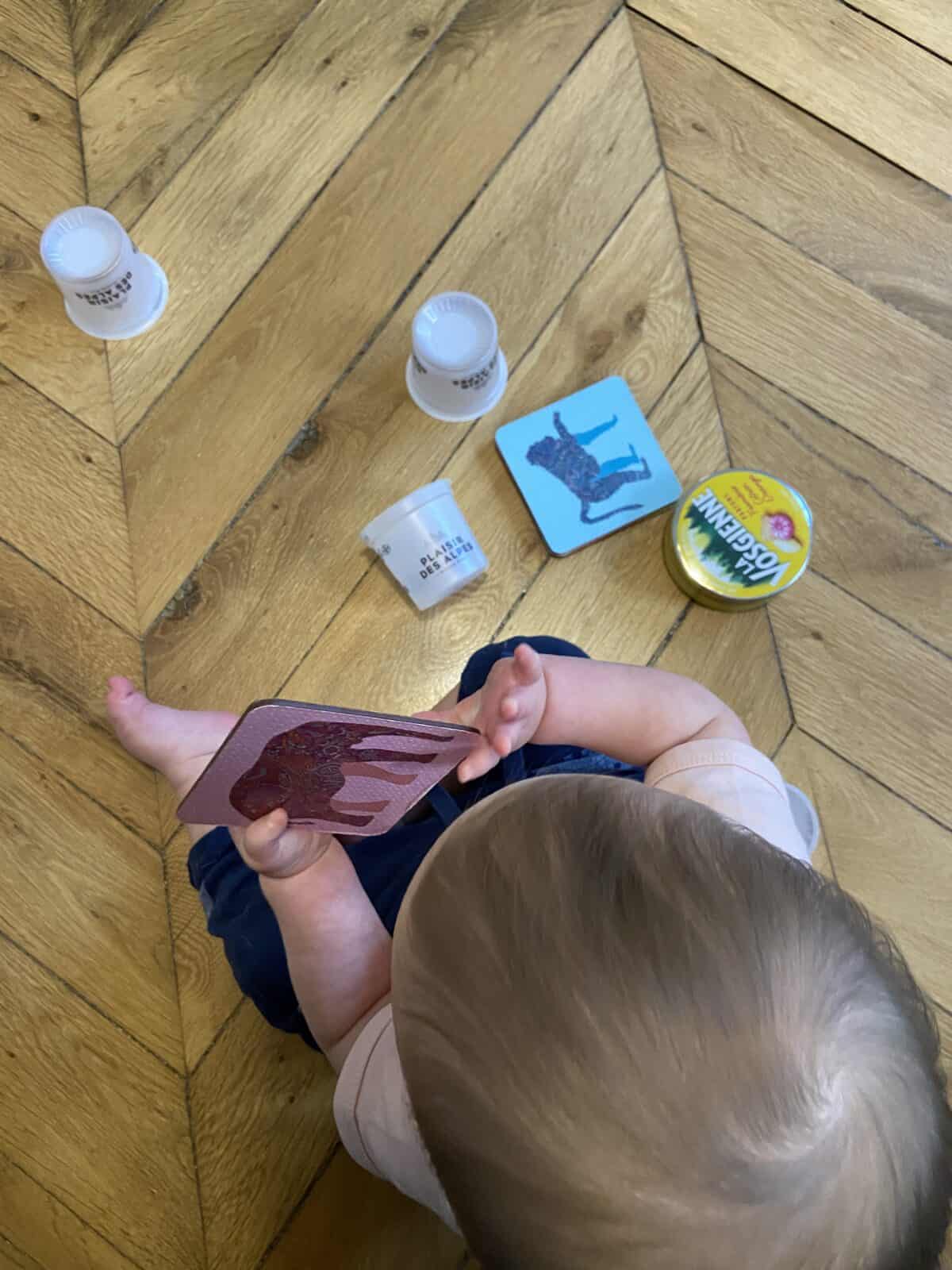 Our Essential Packing List for Travel with a Baby 32 Baby C playing with coasters, plastic yogurt containers and a empty tin of candy