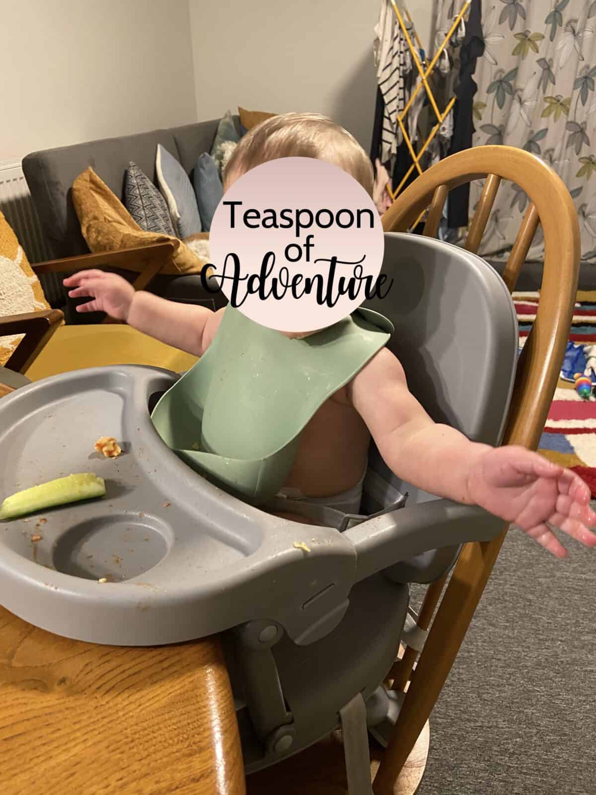 Our Essential Packing List for Travel with a Baby 27 Baby C sitting in her travel high chair that is strapped to a dining chair
