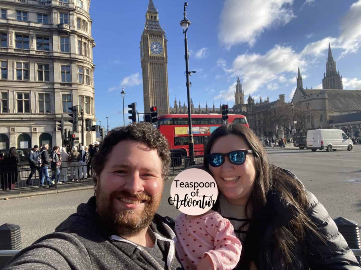20+ Things to Do in London With a Baby 47 A selfie of Riana, Colin and Baby C in front of Big Ben in London while a red double decker bus drives by