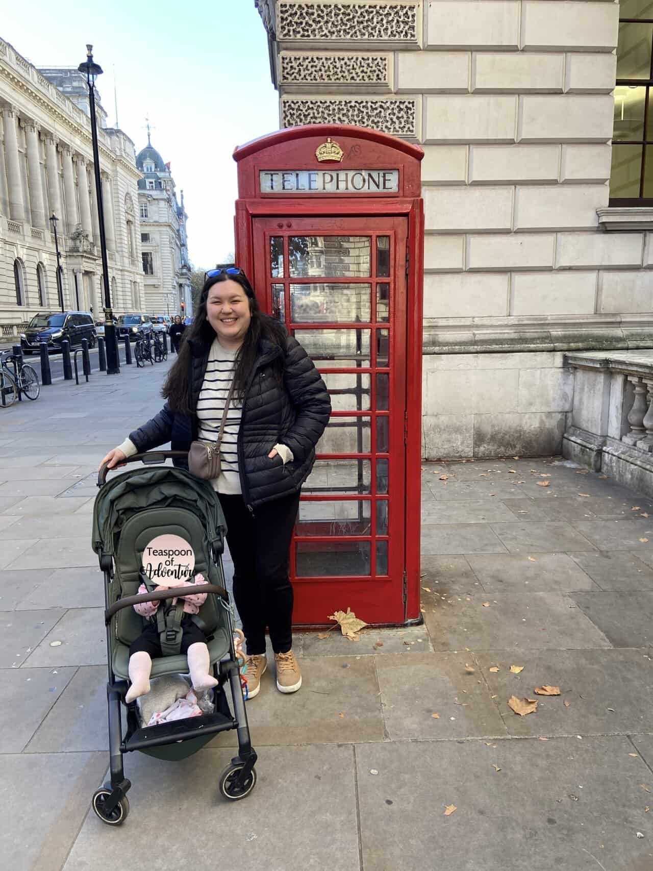 Joolz Aer Review: Is This the Best Travel Stroller? 2 Riana and Baby C in her stroller standing in front of a red phone booth on the streets of London