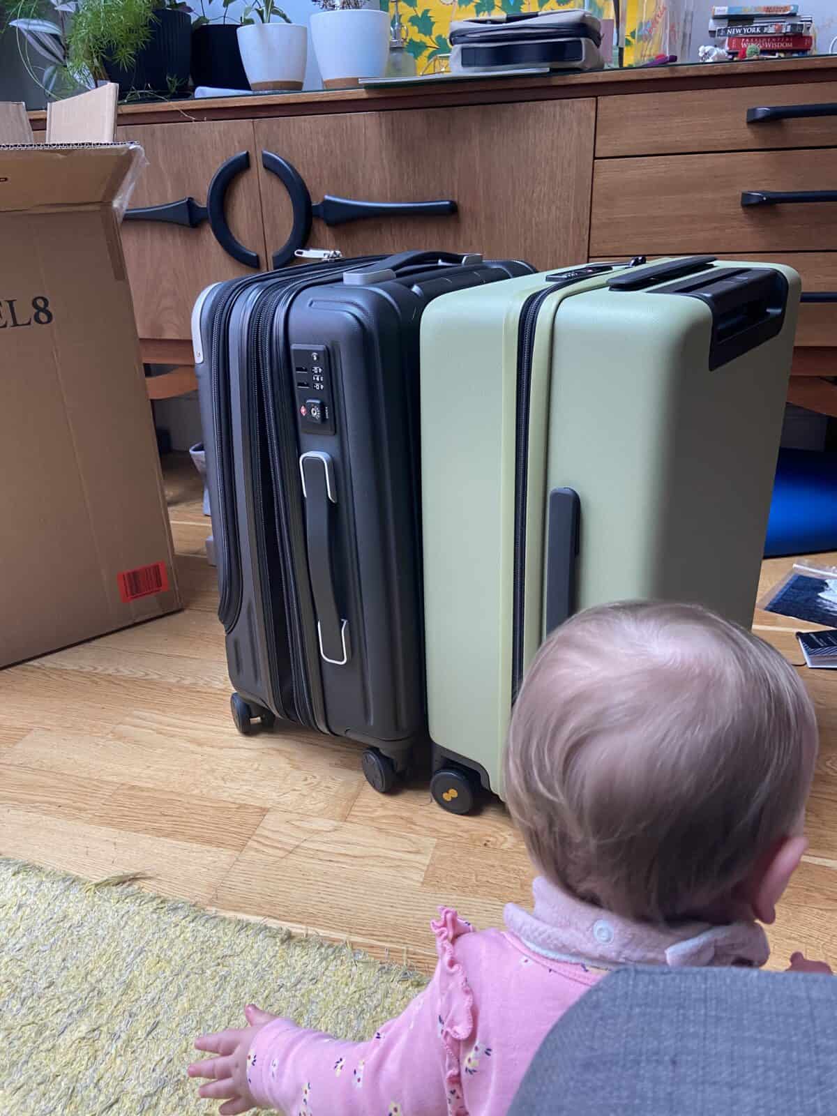 Our Essential Packing List for Travel with a Baby 40 Baby C looking at her new LEVEL8 suitcases being packed for travel with a baby