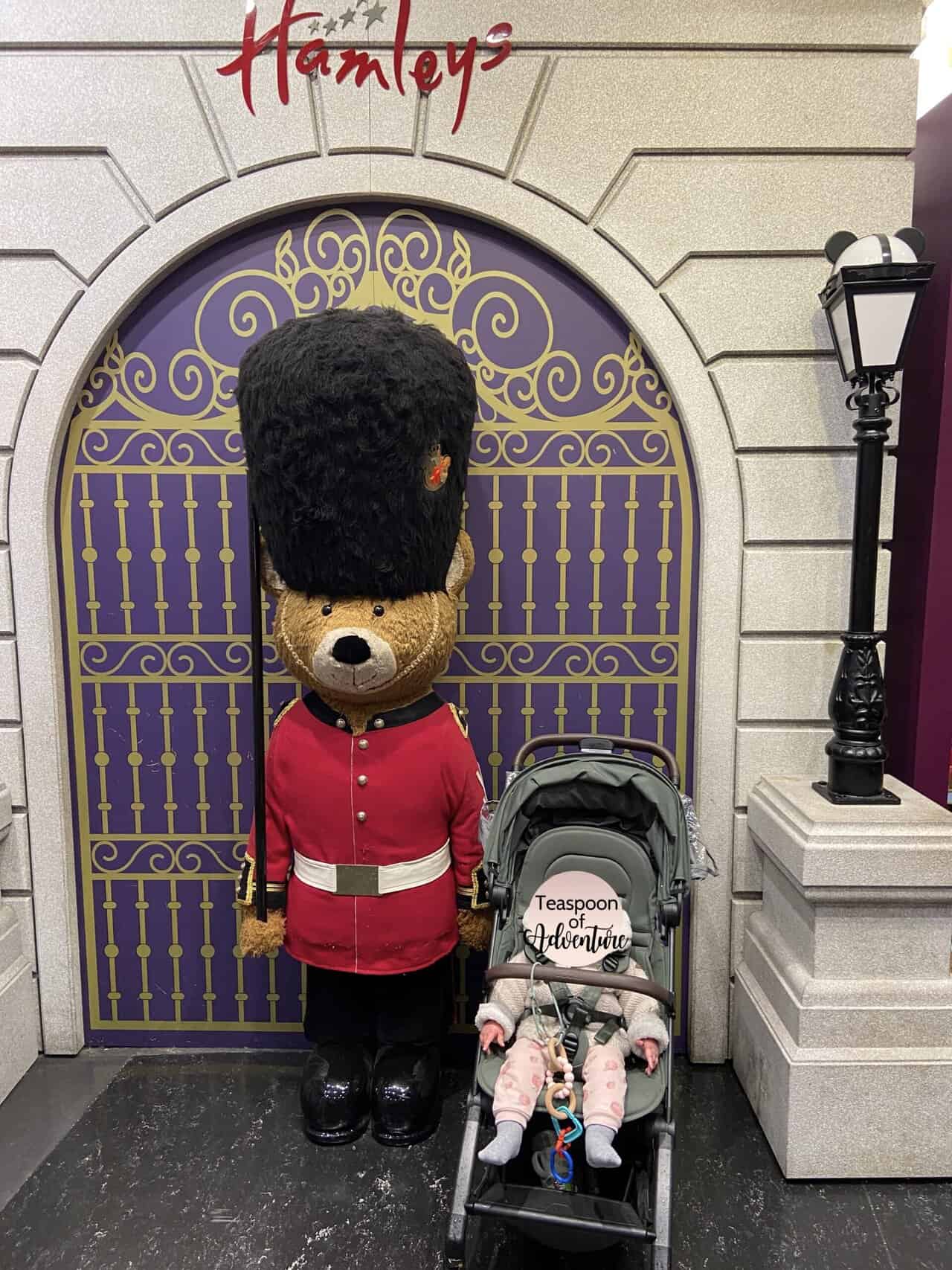 20+ Things to Do in London With a Baby 33 Baby C in her stroller next to a bear statue at Hamley's toy store in London