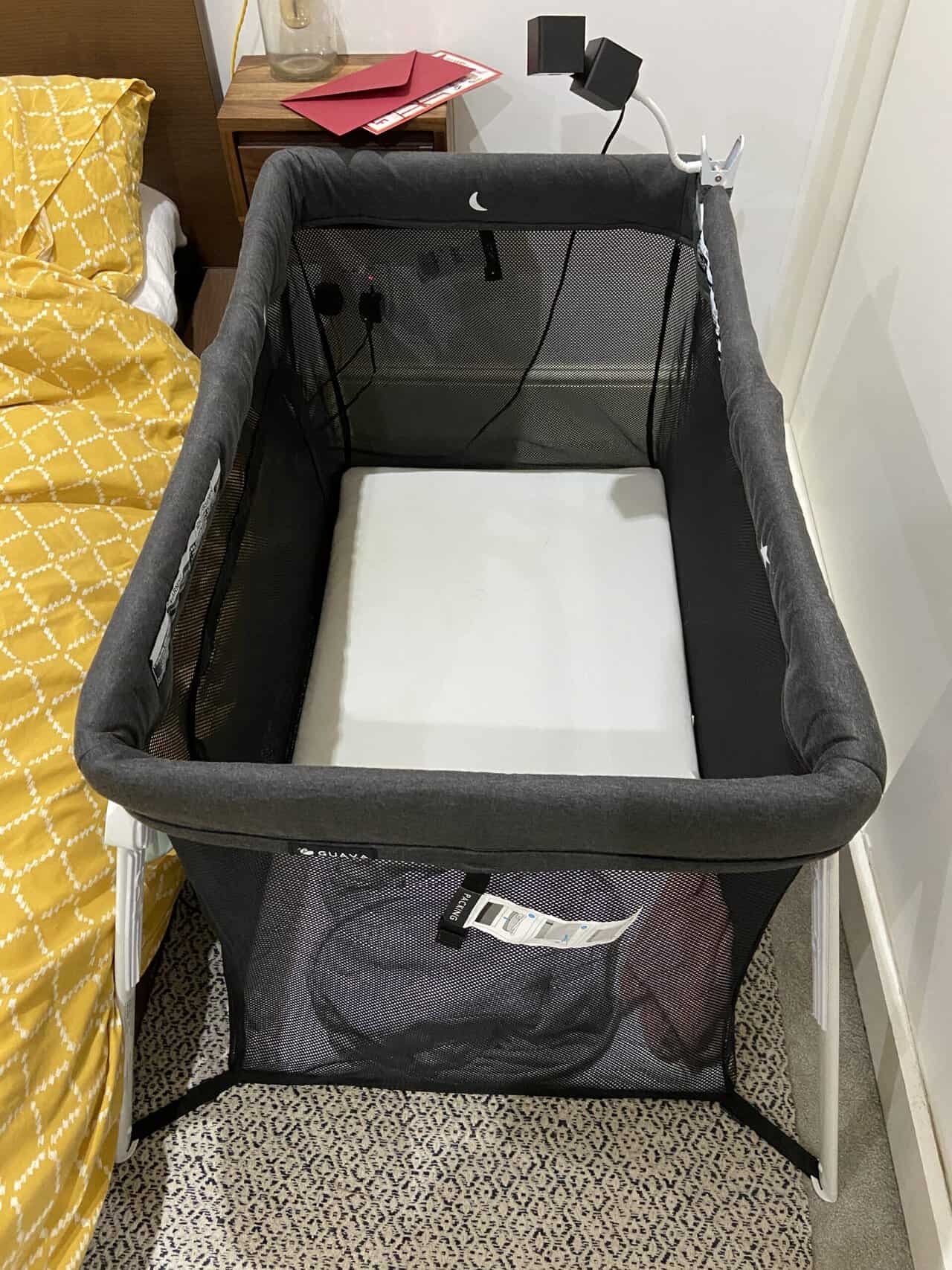 Tips for Flying With a Baby: From Booking to Baggage Claim 18 Our Guava Family Travel Crib sitting next to our bed