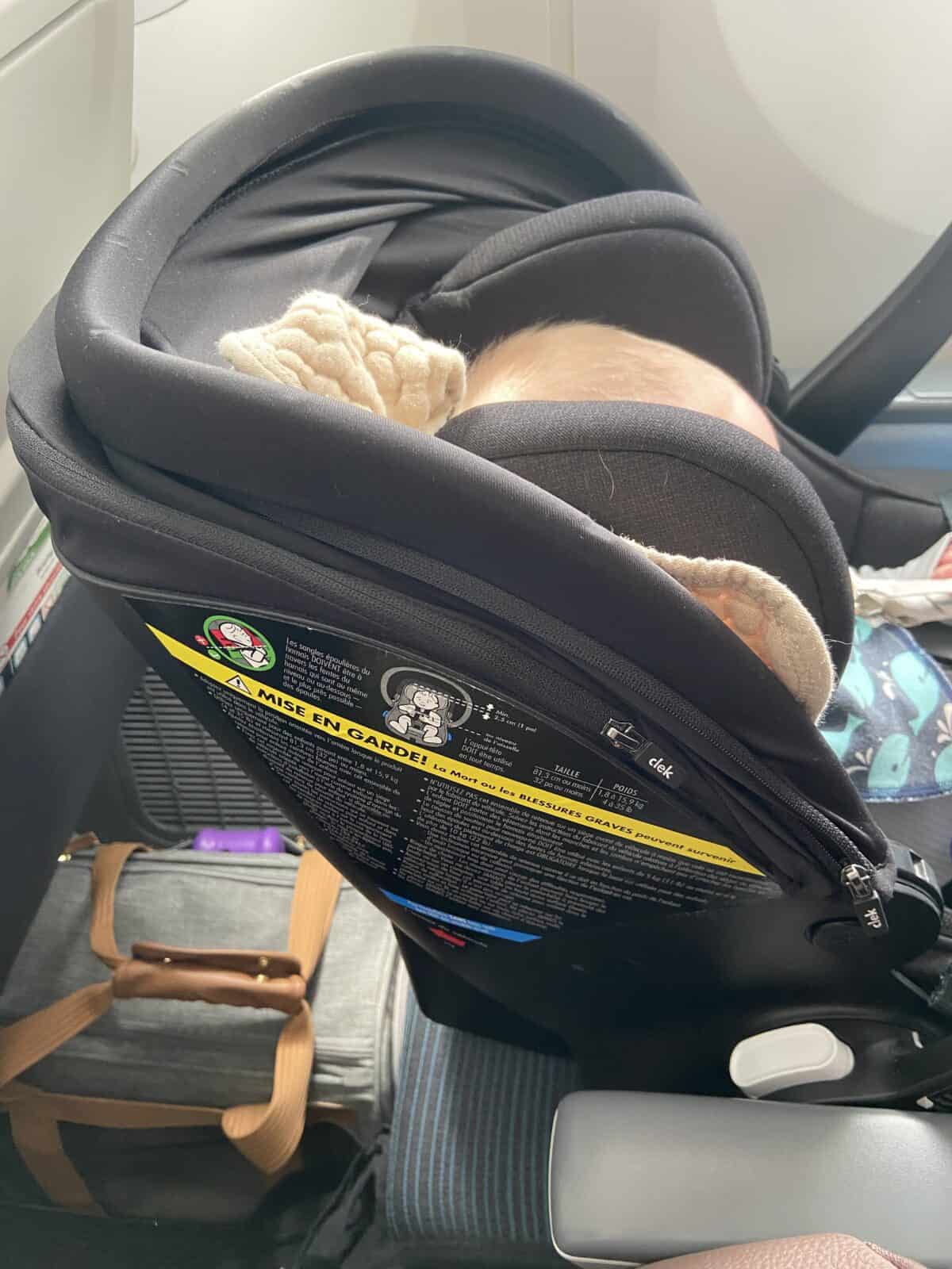 Our Essential Packing List for Travel with a Baby 18 Clek Liingo car seat strapped into an airplane seat