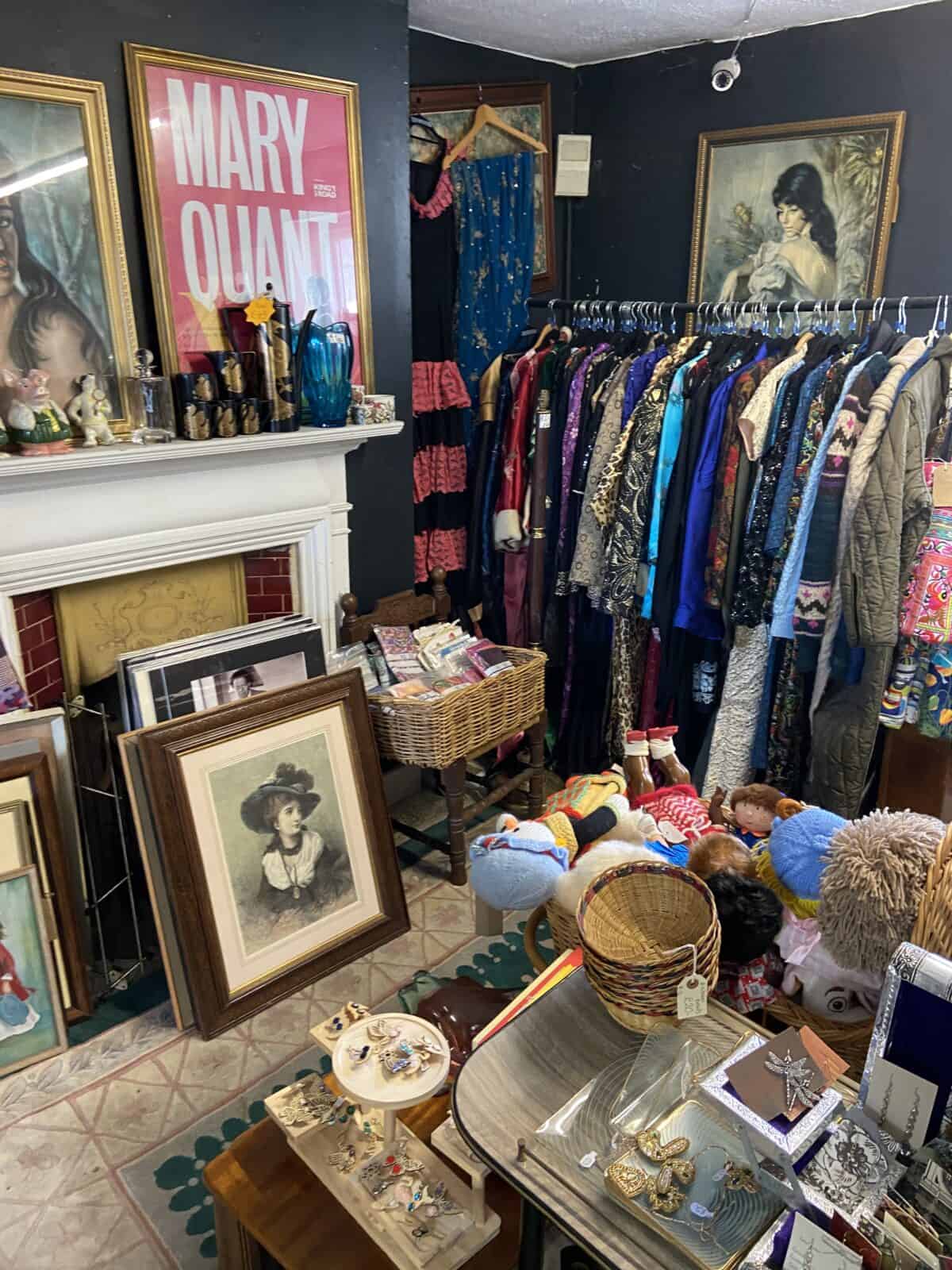 Your Guide to Brighton's North Laine 17 Inside a room of North Laine Bazaar with antique paintings and a rack of clothing, Brighton
