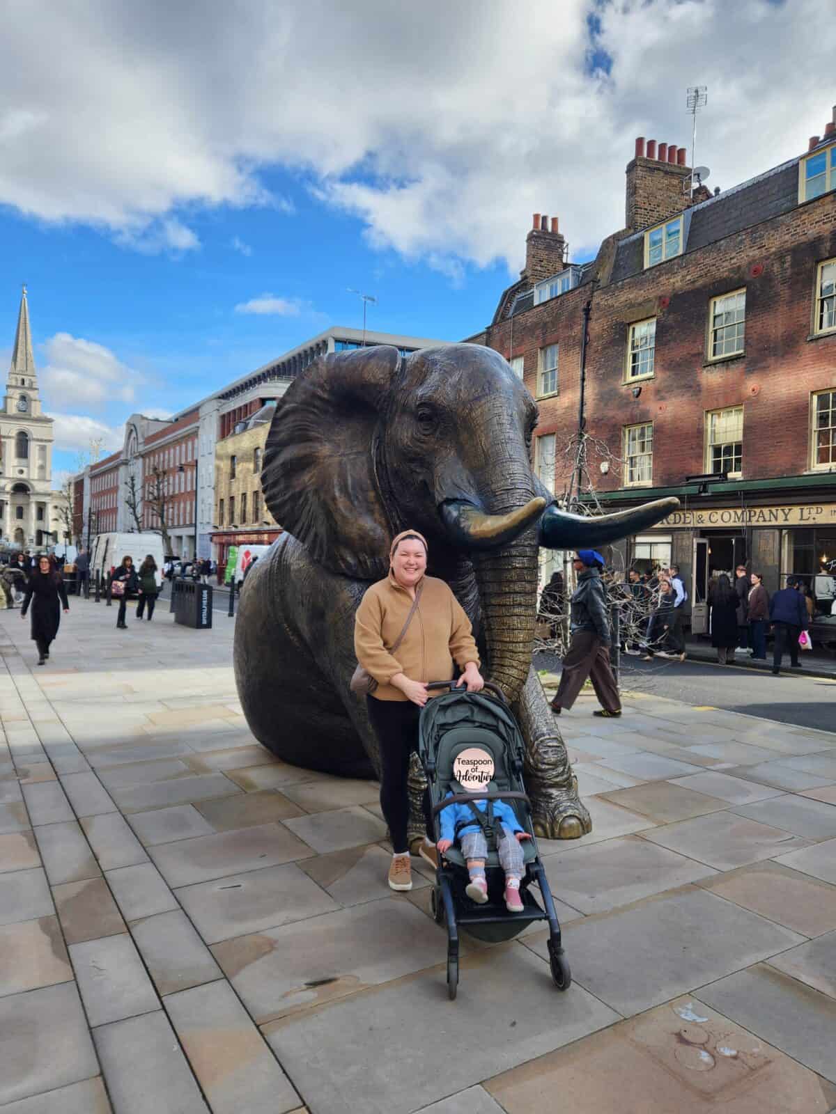 Joolz Aer Review: Is This the Best Travel Stroller? 12 Riana and Baby C in her stroller in front of the elephant statue at Old Spitalfields Market in London