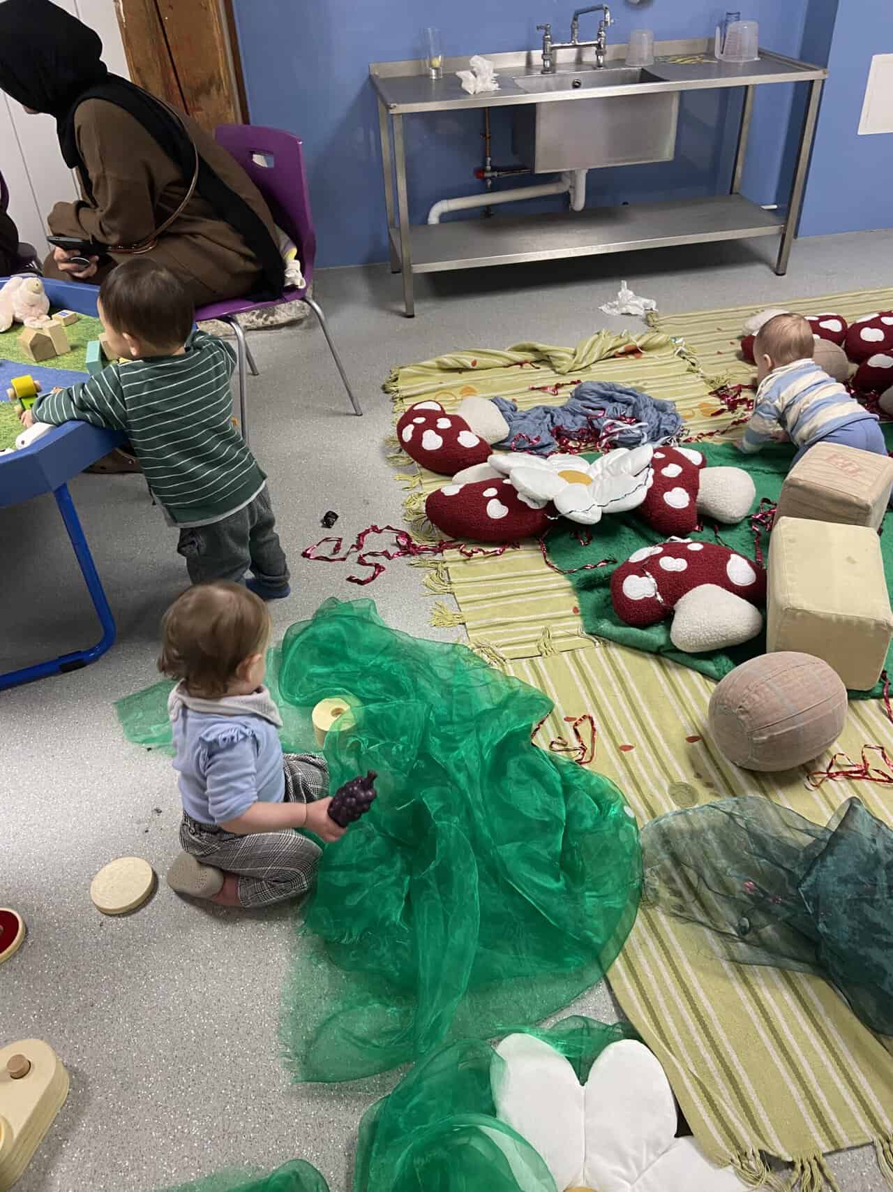 20+ Things to Do in London With a Baby 11 Baby C playing with cushions, tulle and other babies at Tots at the Docks drop in play session at London Museum Docklands