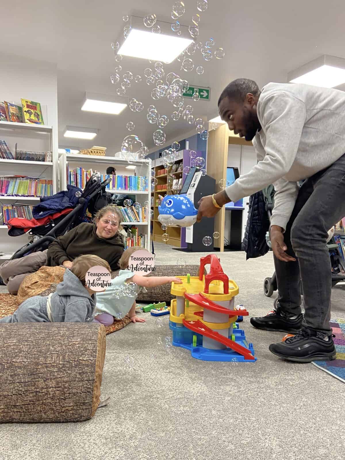 20+ Things to Do in London With a Baby 21 Baby C and another baby playing with toys while a librarian brings out a bubble machine in the kids' section of Artizan Street Library in Spitalfields, London