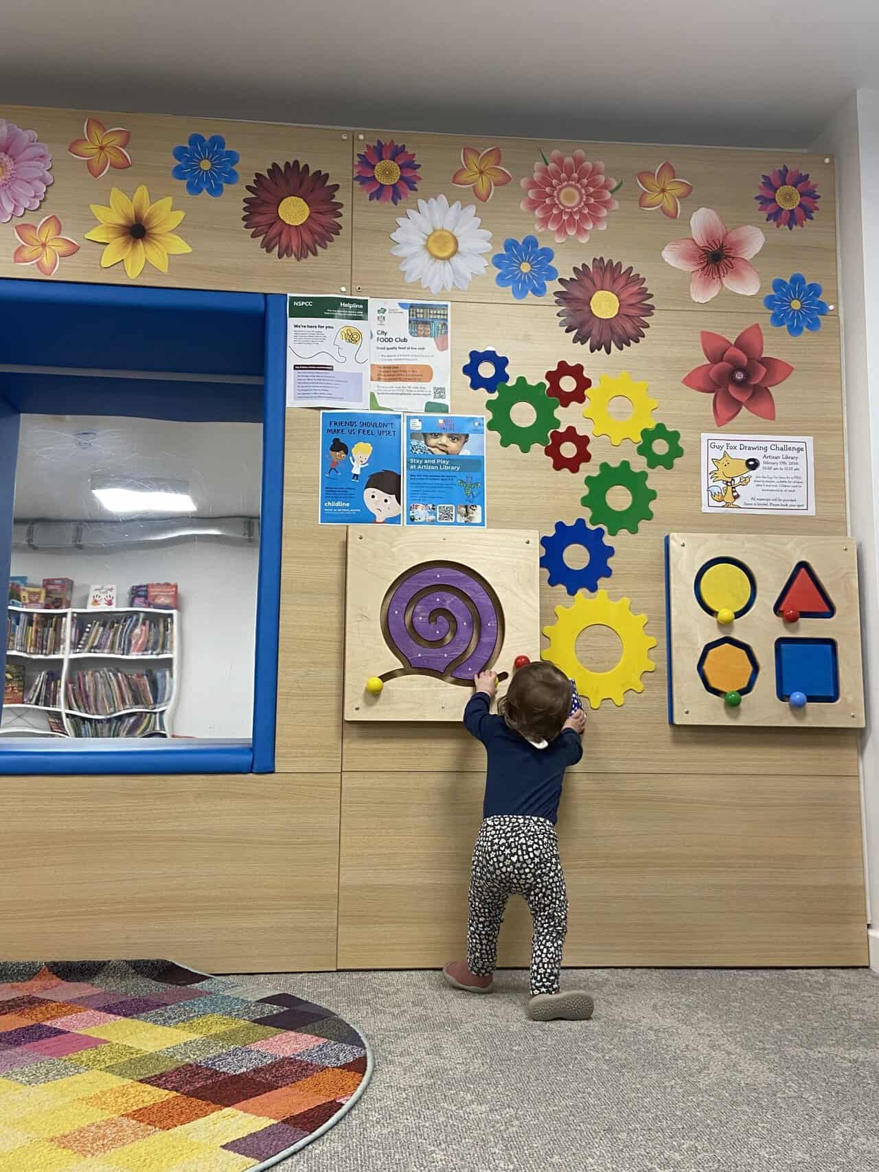 20+ Things to Do in London With a Baby 19 Baby C playing with toys on the wall in the kids' section of Artizan Street Library in Spitalfields, London