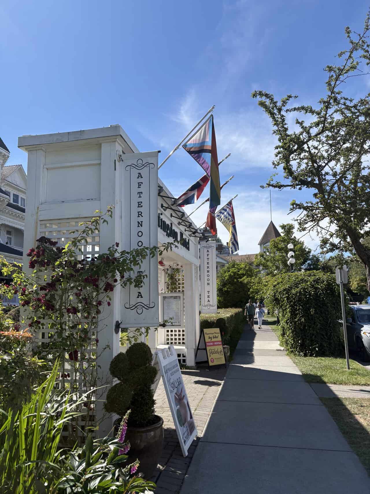 Pendray Tea House Review: Afternoon Tea in Victoria, BC 3 The entrance to Pendray Inn and Tea House with an archway, flags and a sign that reads "afternoon tea"