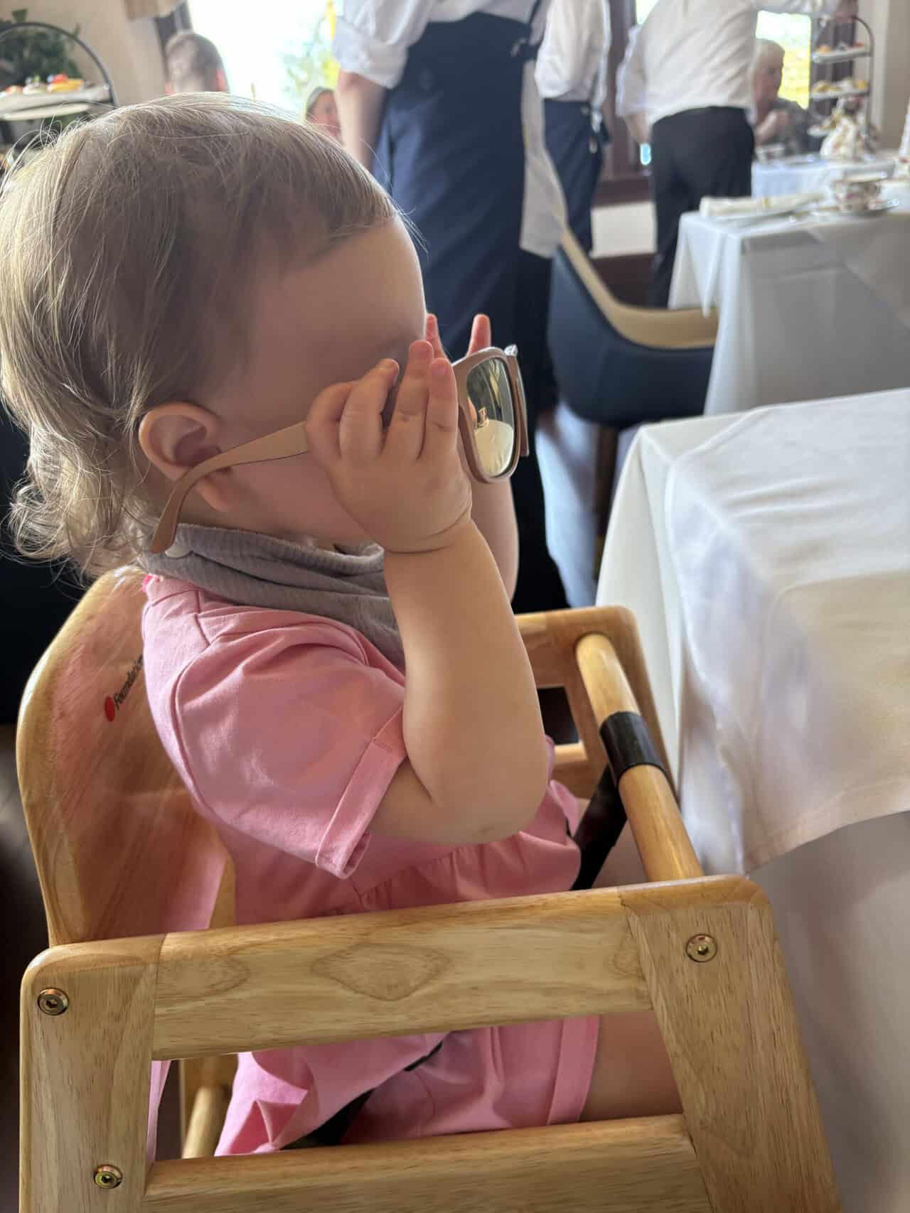 Pendray Tea House Review: Afternoon Tea in Victoria, BC 13 Baby C in her high chair playing with her pink sunglasses at Pendray Teahouse in Victoria