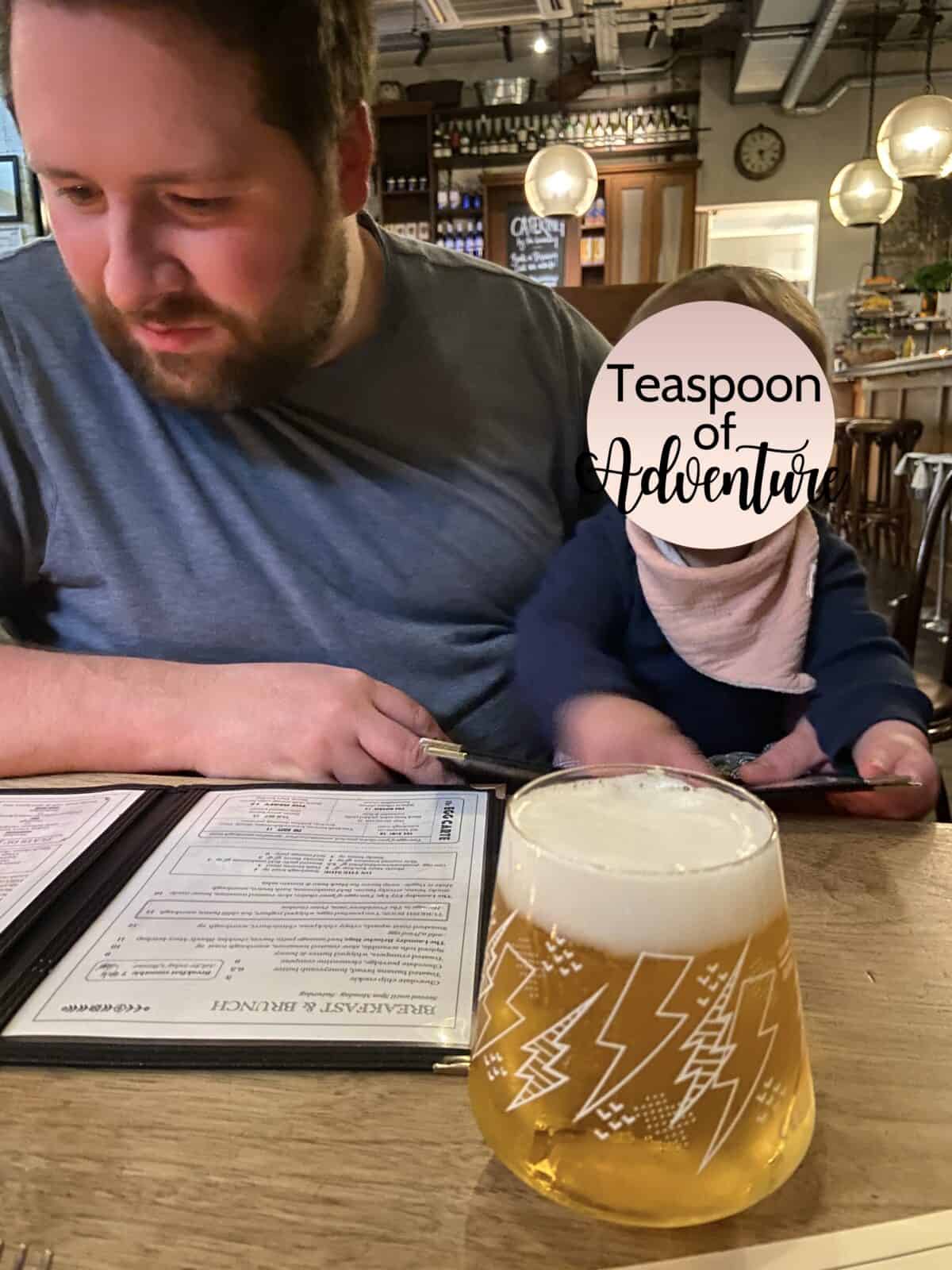 20+ Things to Do in London With a Baby 45 Colin and Baby C at The Laundry restaurant in Brixton, London studying the menu with a beer in front of them on the table