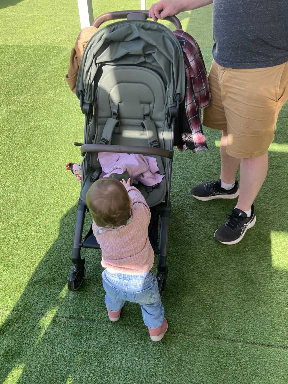 Joolz Aer Review: Is This the Best Travel Stroller? 13 Baby C pushing her Joolz Aer stroller on turf in Malaga, Spain