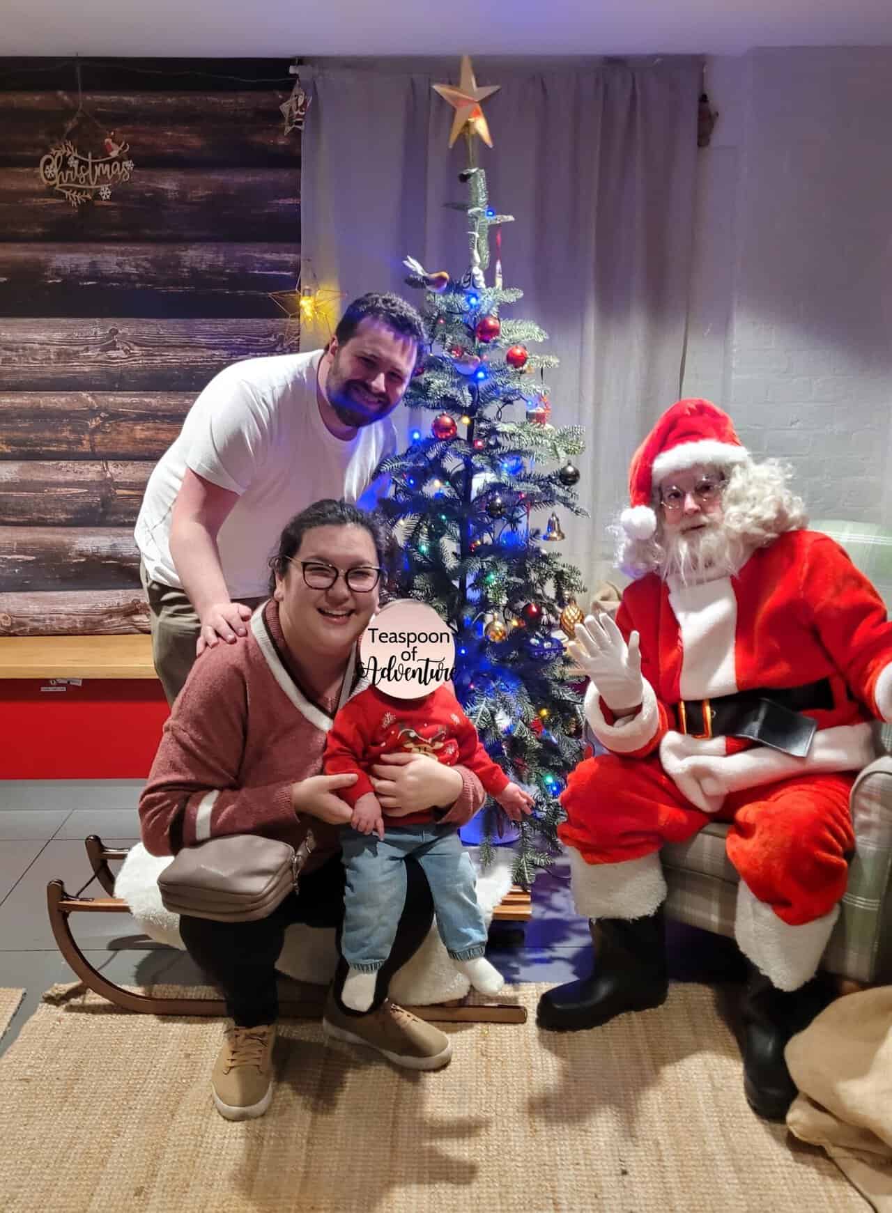 20+ Things to Do in London With a Baby 44 Colin, Riana and Baby C pose on a sleigh and next to a Christmas tree while meeting Santa at the London Transport Museum