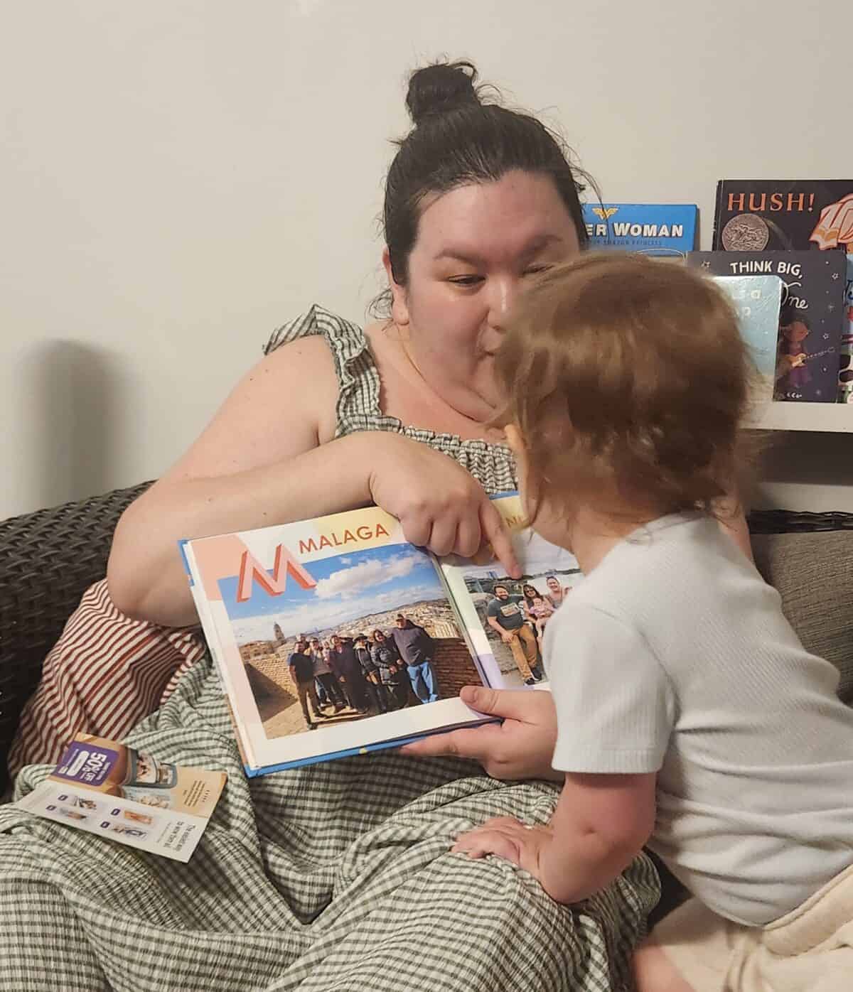 Making A Custom Board Book From Our Travel Photos 7 Riana holding open the custom travel photo book she created for Baby C and reading it to her daughter