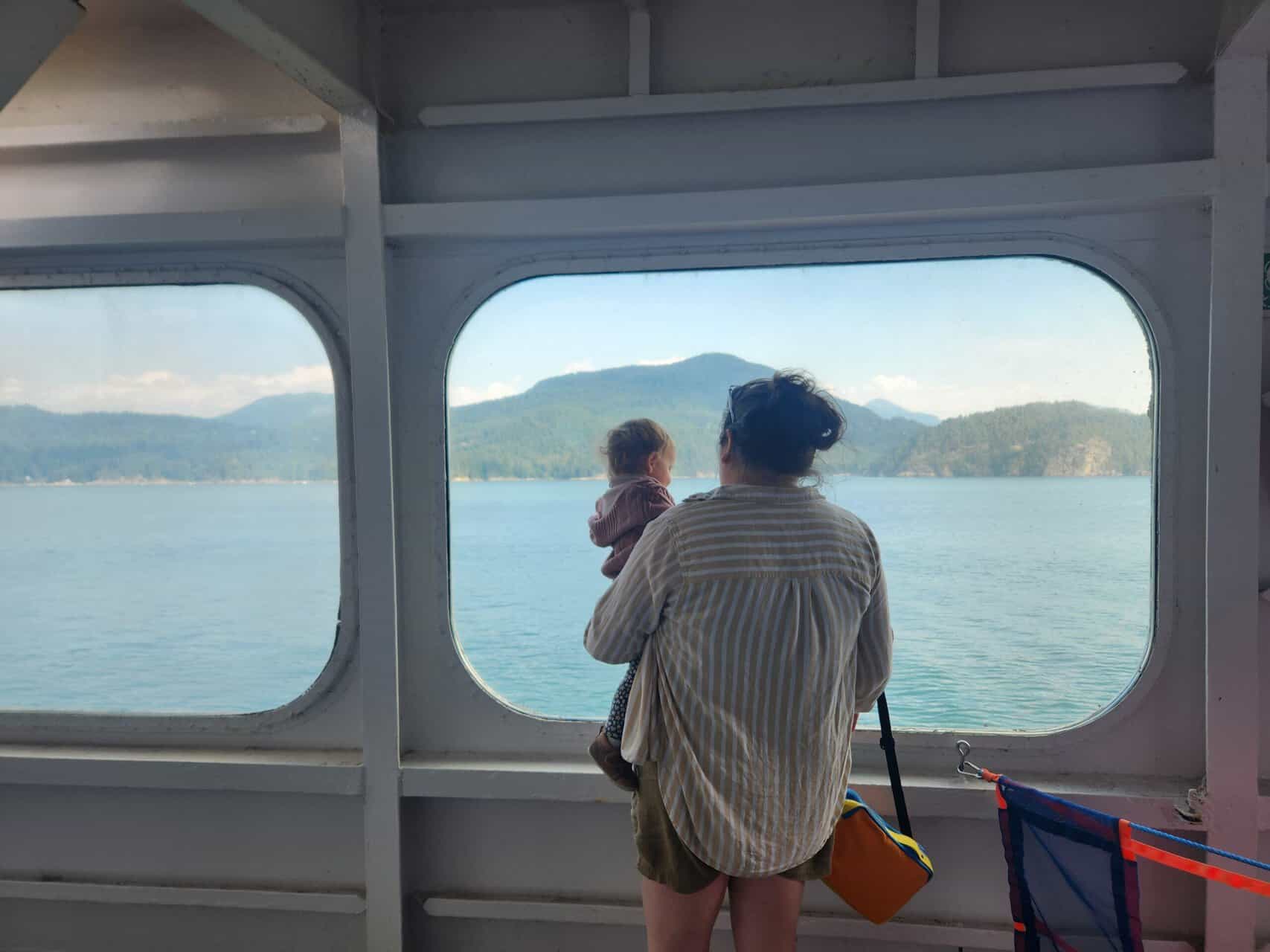 How to Get to Victoria from Vancouver, BC 8 Riana holding Baby C on a BC Ferry looking out the window at the ocean and islands