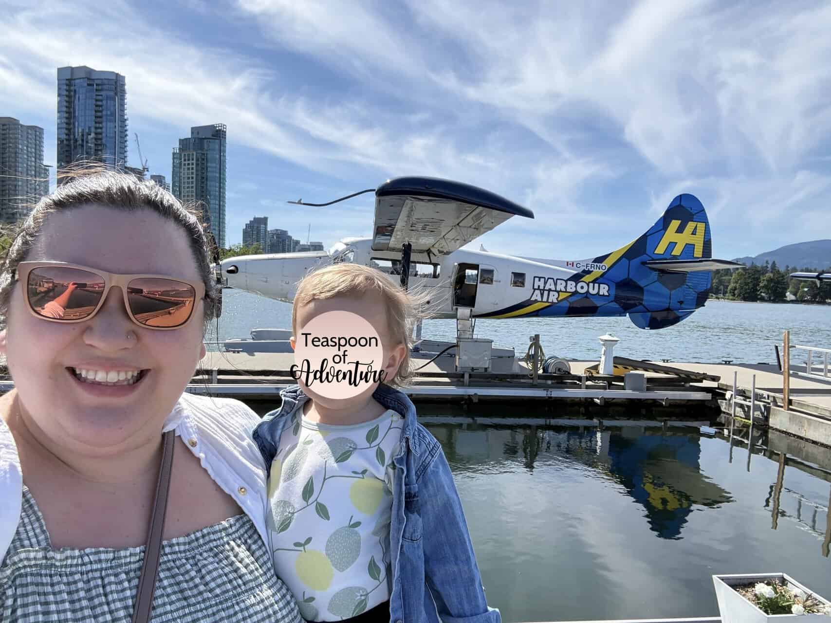 Should You Take a Seaplane to Victoria from Vancouver? (Harbour Air Review) 29 Riana smiling while holding Baby C for a selfie in front of a Harbour Air seaplane