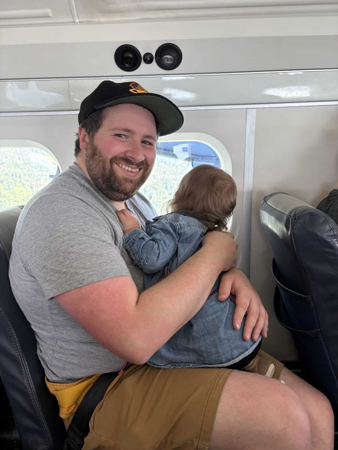Should You Take a Seaplane to Victoria from Vancouver? (Harbour Air Review) 17 Colin smiling while holding Baby C on his lap on board a Harbour Air seaplane
