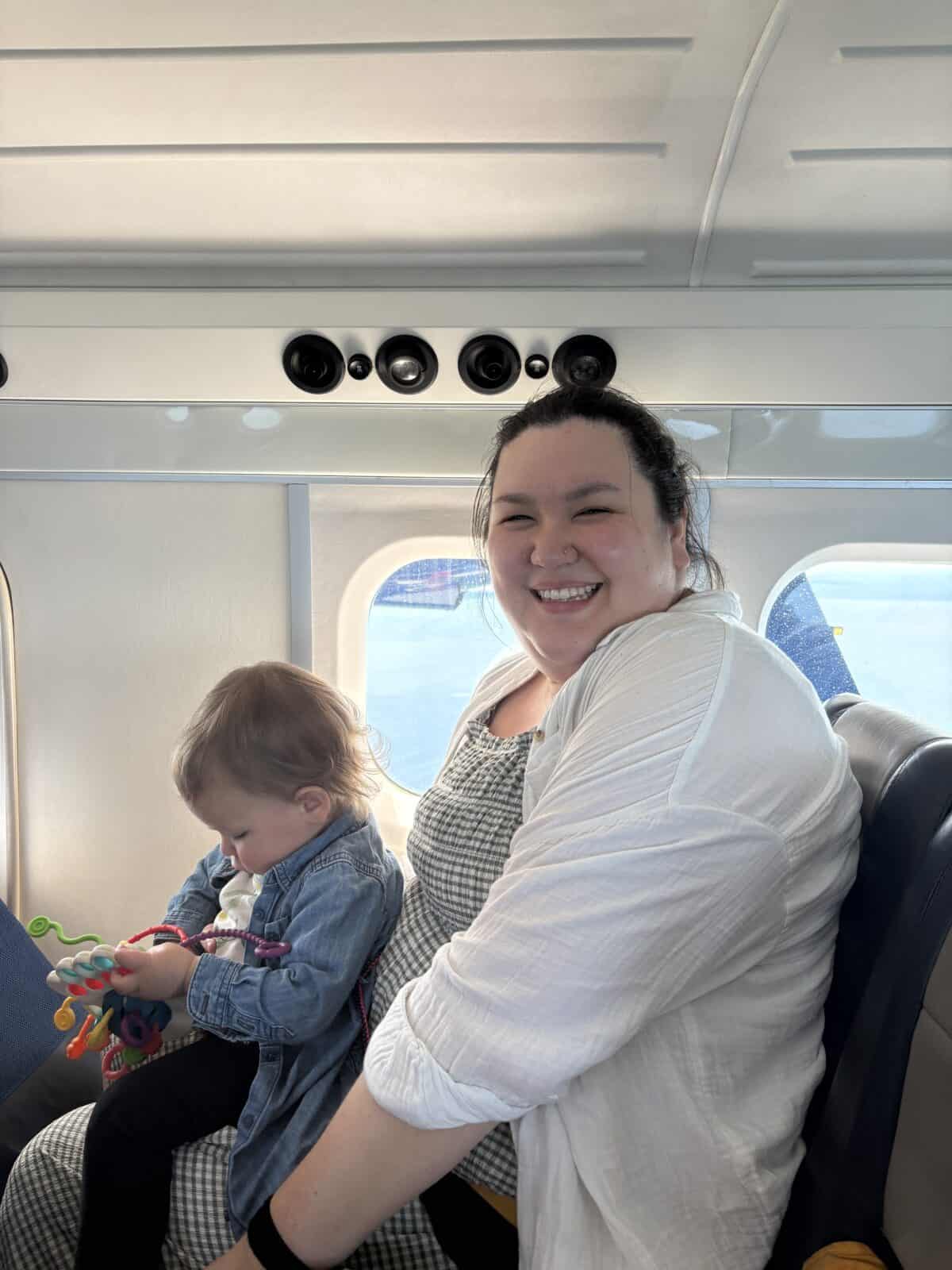 How to Get to Victoria from Vancouver, BC 7 Riana smiling at the camera with Baby C on her lap on board a Harbour Air seaplane to Victoria