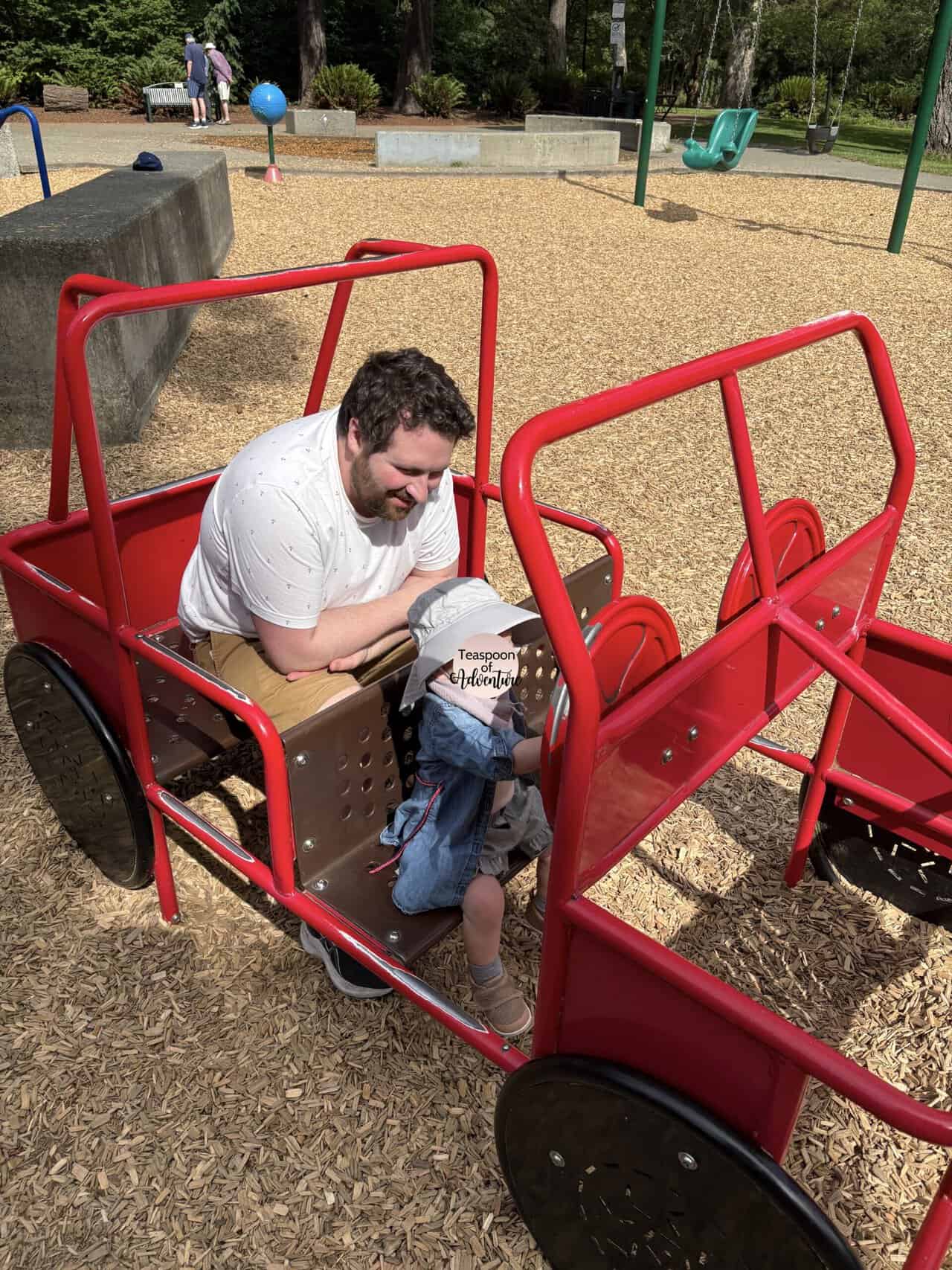 Baby C in a red metal car structure at the Beacon Hill Park North Playground