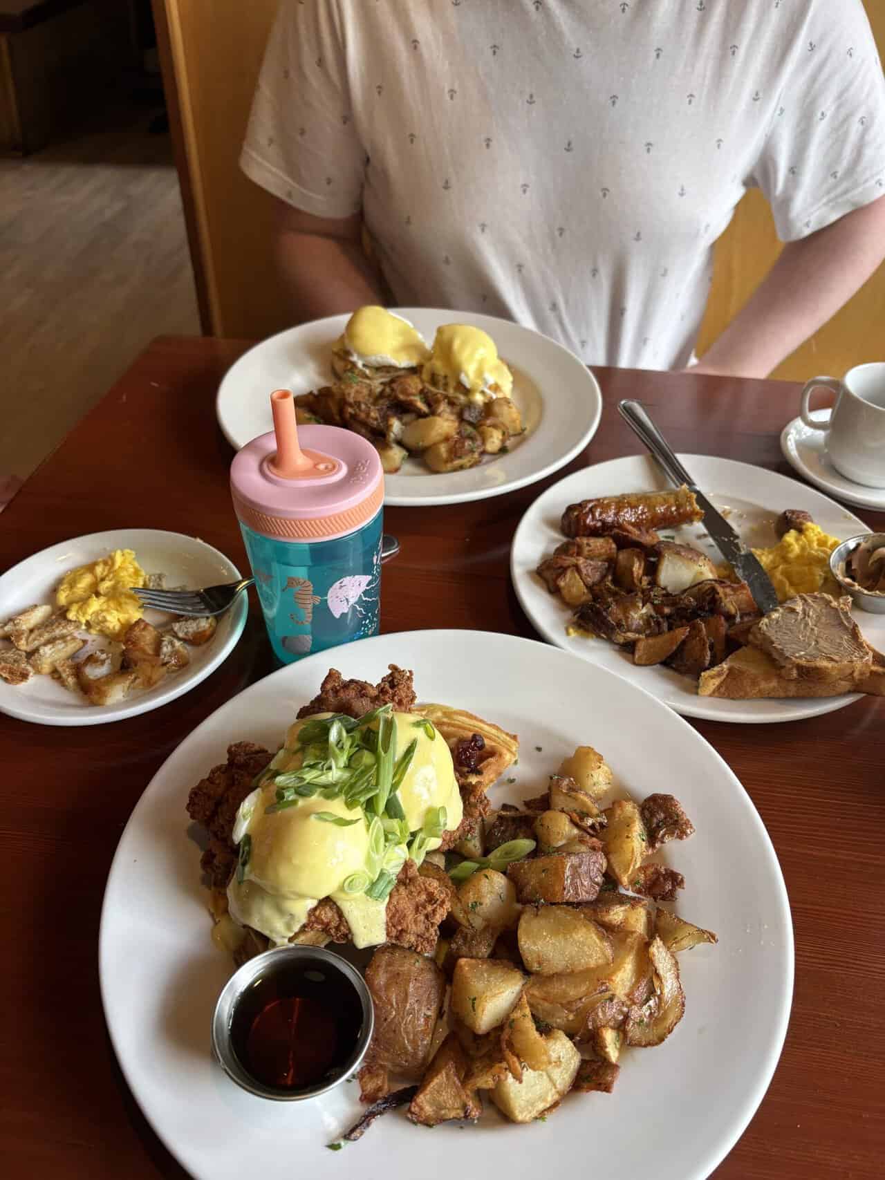 Eggs Benedicts - one with chicken and bacon on waffles and another with crab and shrimp - and a kids breakfast with eggs, sausage and potatoes from Rock Heron Bistro in Victoria, BC