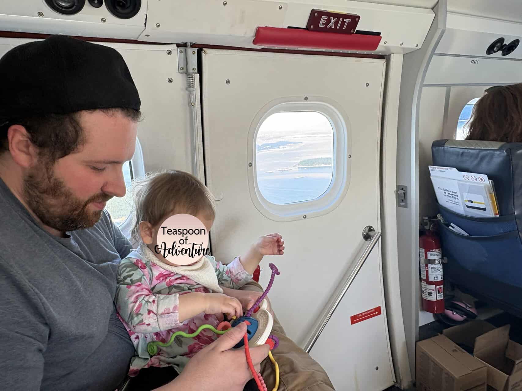 Should You Take a Seaplane to Victoria from Vancouver? (Harbour Air Review) 23 Baby C sitting on Colin's lap inside a Harbour Air seaplane playing with toys